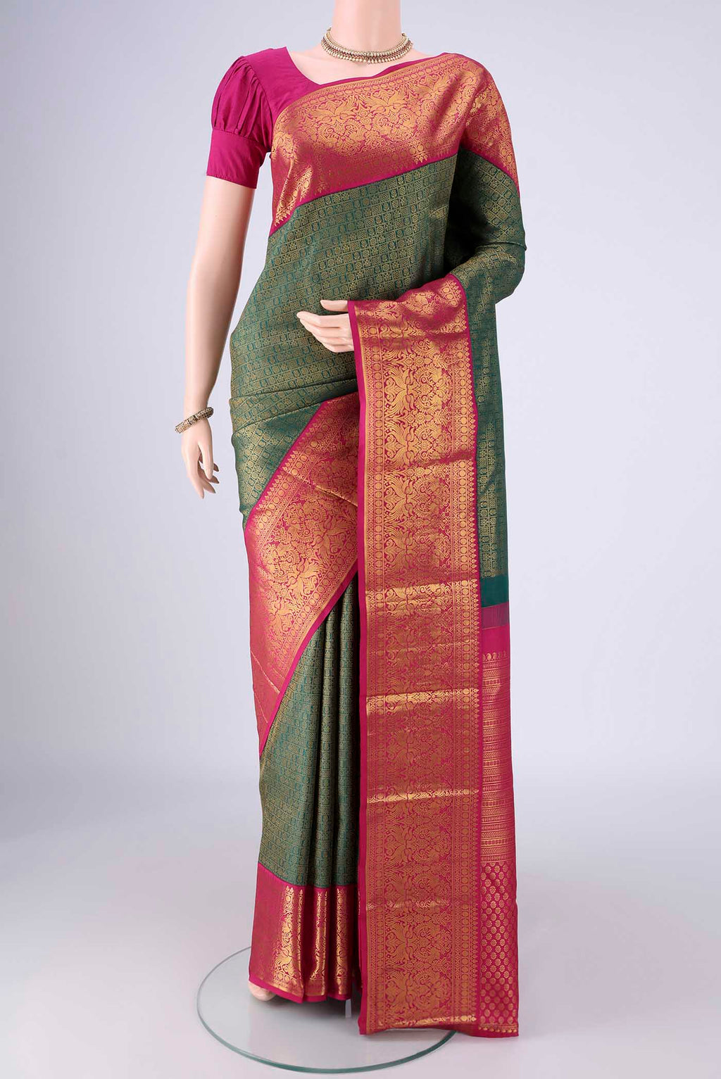 Bottle Green Kanjivaram Silk Saree with Zari Brocade on the body and Zari Border.  displayed on a mannequin