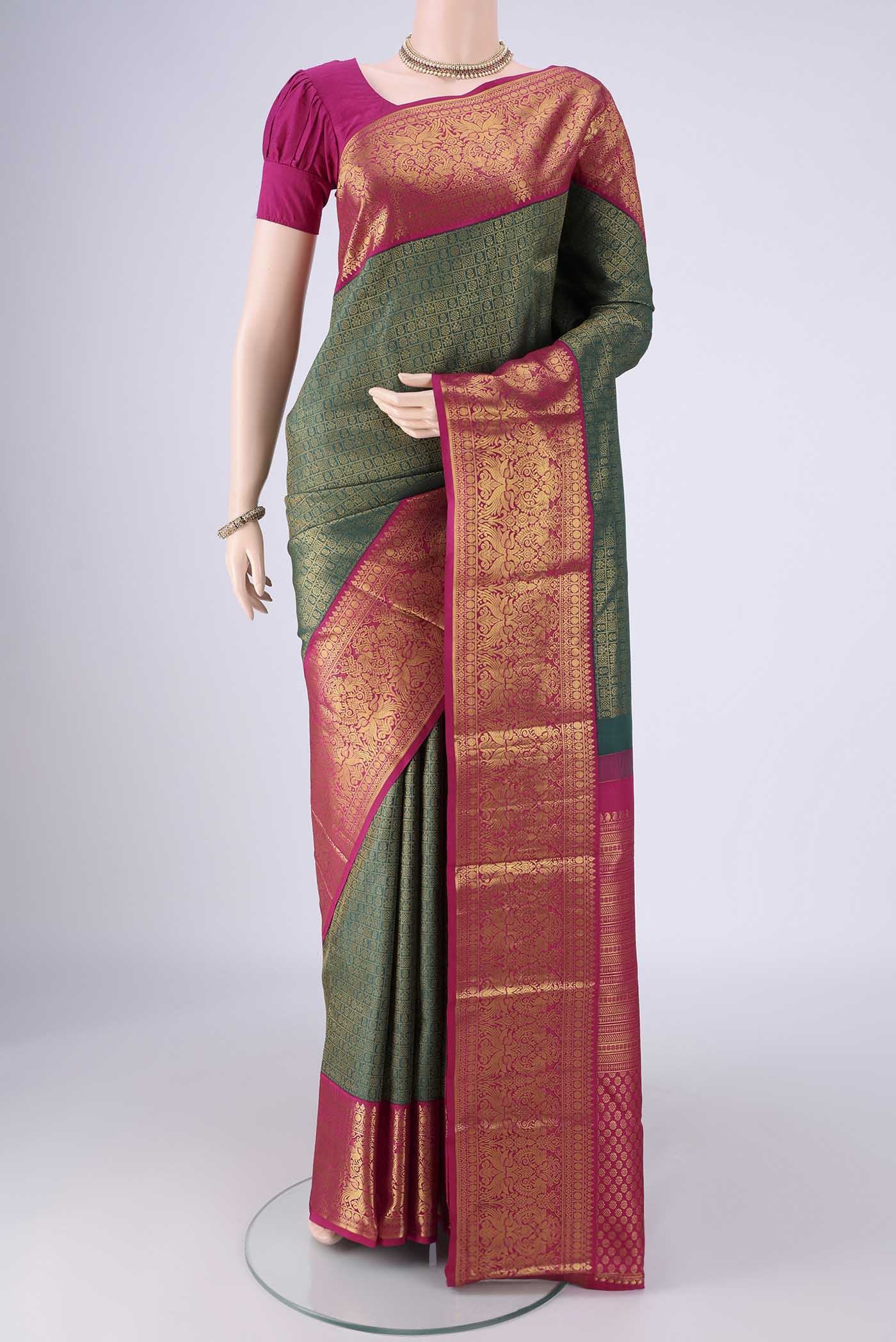 Bottle Green Kanjivaram Silk Saree with Zari Brocade on the body and Zari Border.  displayed on a mannequin