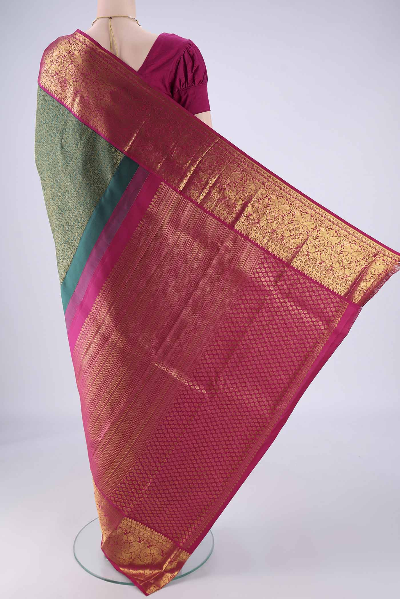 Flat view of Bottle Green Kanjivaram Silk Saree with Zari Brocade on the body and Zari Border. 