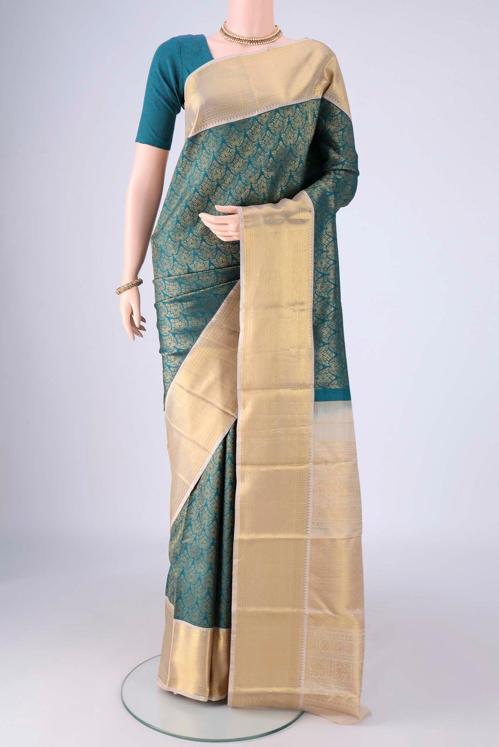 Teal Kanjivaram Silk Saree with Zari Brocade on the body and Zari Border.  displayed on a mannequin