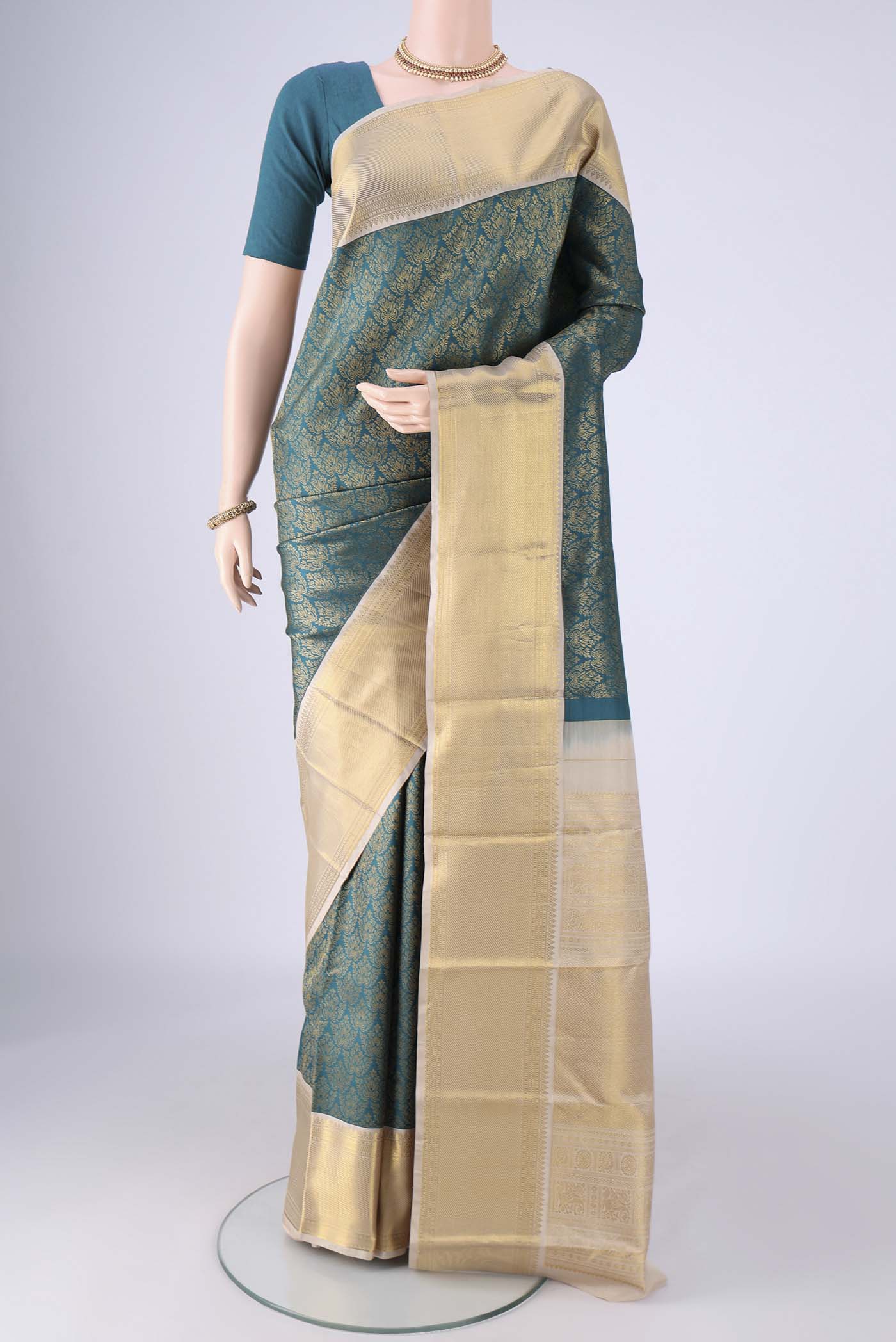 Teal Kanjivaram Silk Saree with Zari Brocade on the body and Zari Border.  displayed on a mannequin