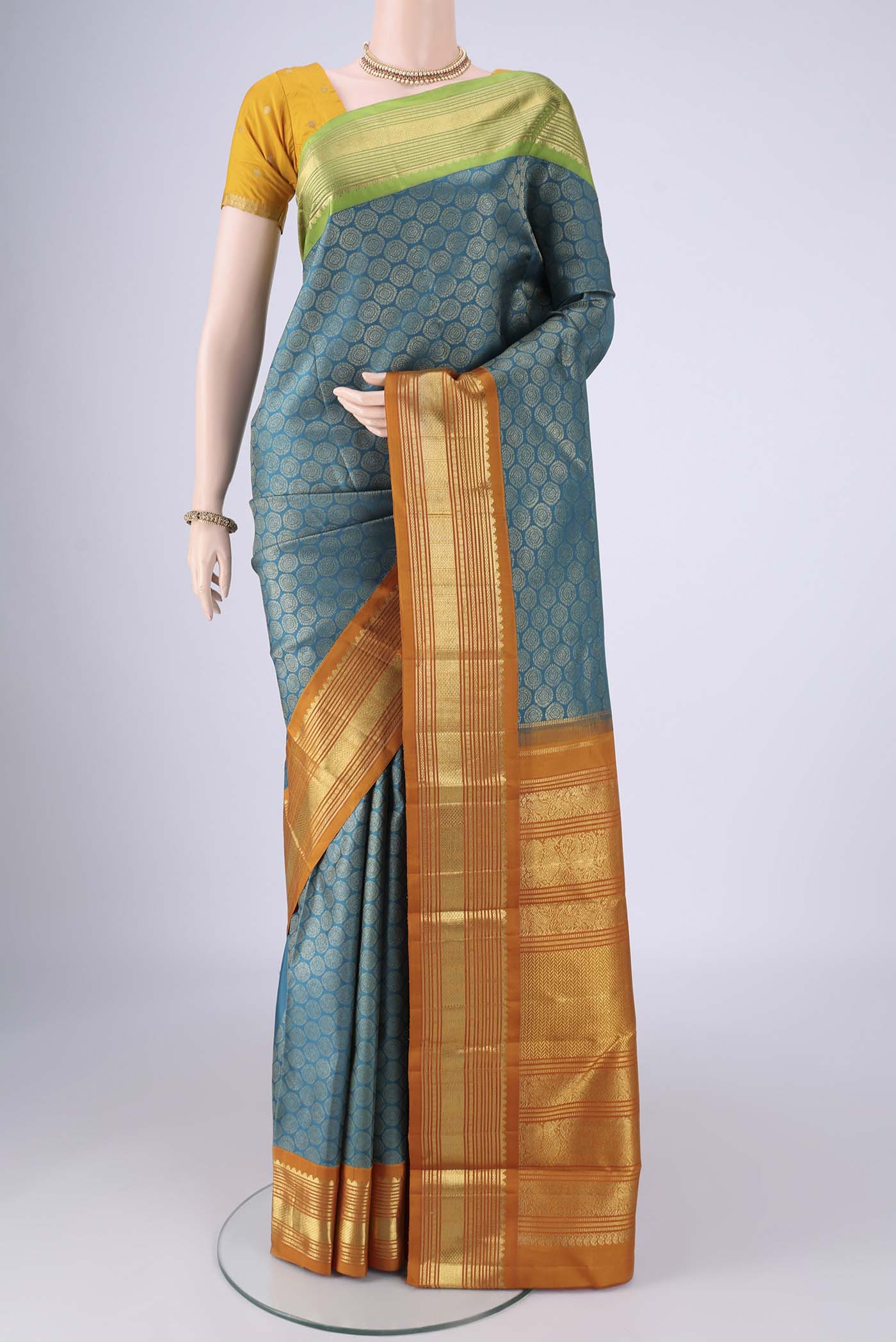Pure Silk Pure Zari Teal Kanjivaram Saree with Zari Brocade on the body and Ganga Jamuna Border.  displayed on a mannequin