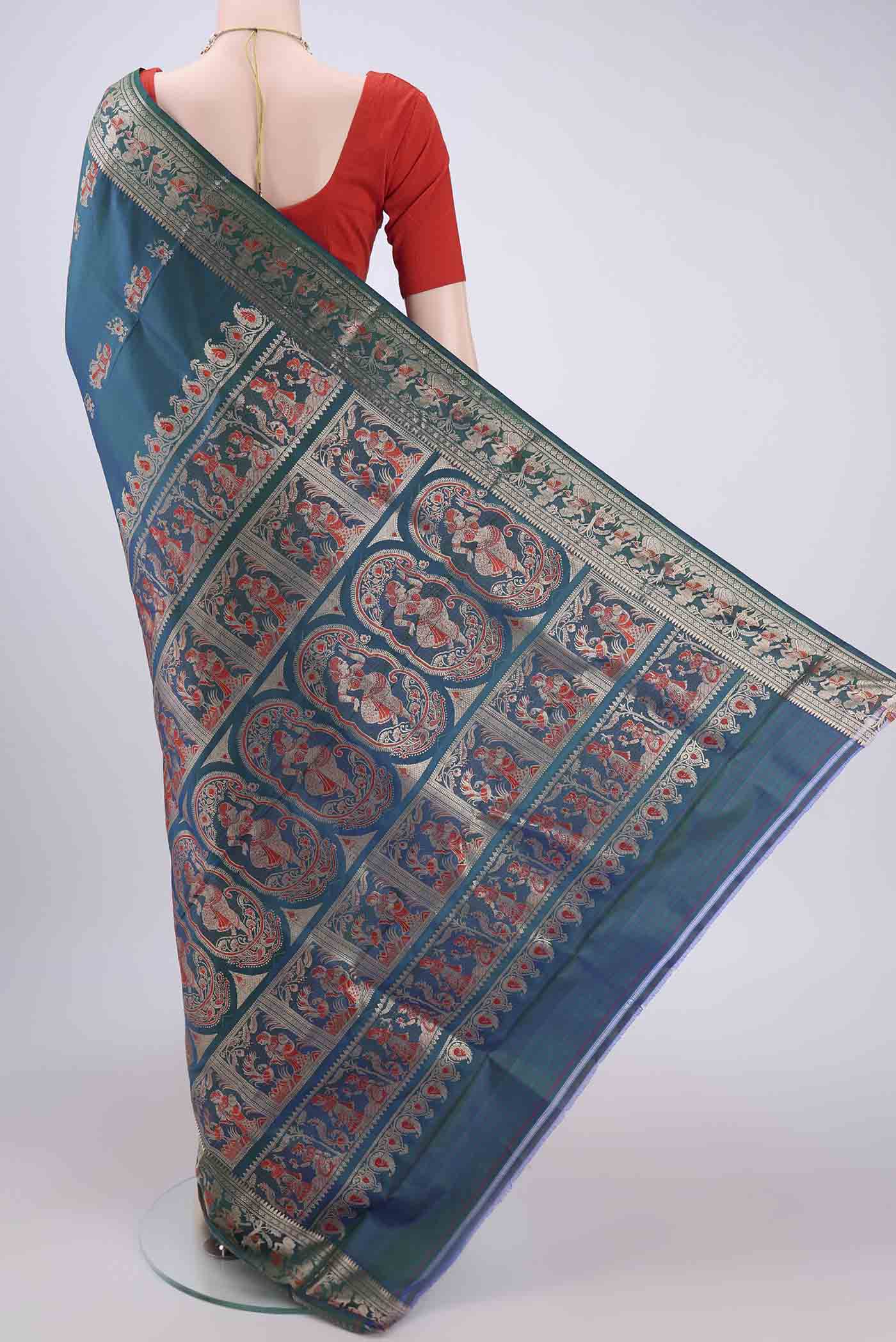 Flat view of Peacock Blue Baluchari Silk Saree with Zari And Thread Butta on the body and Zari And Thread Border. 