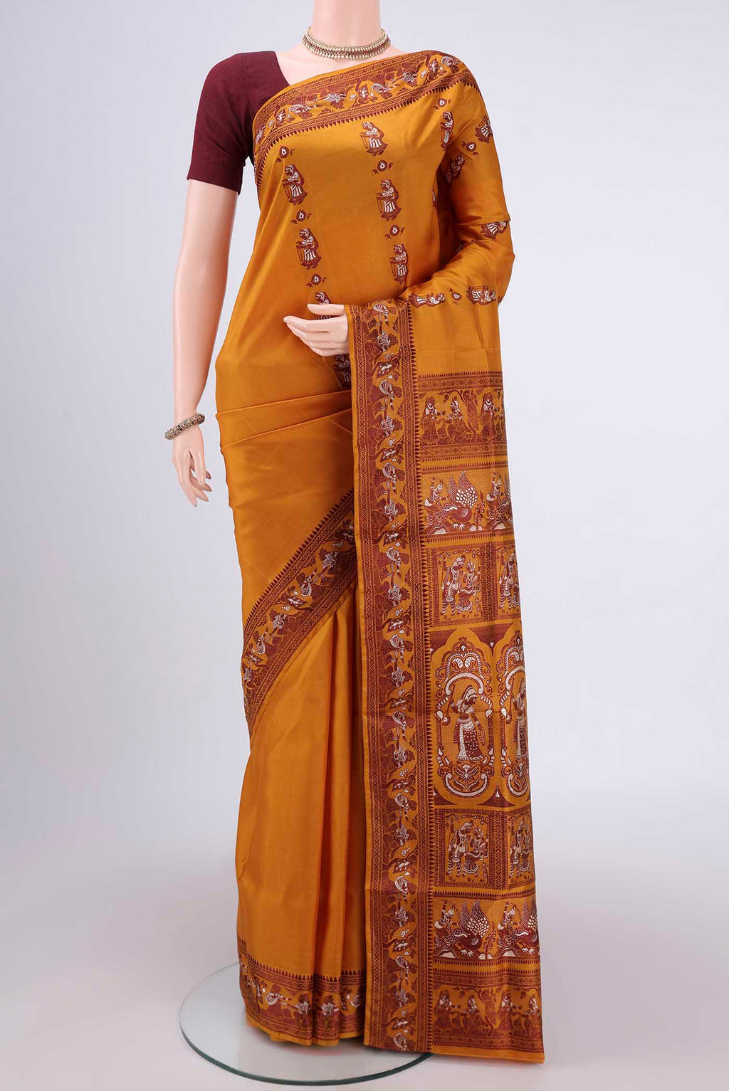 Mustard Baluchari Silk Saree with Thread Butta on the body and Thread Border.  displayed on a mannequin