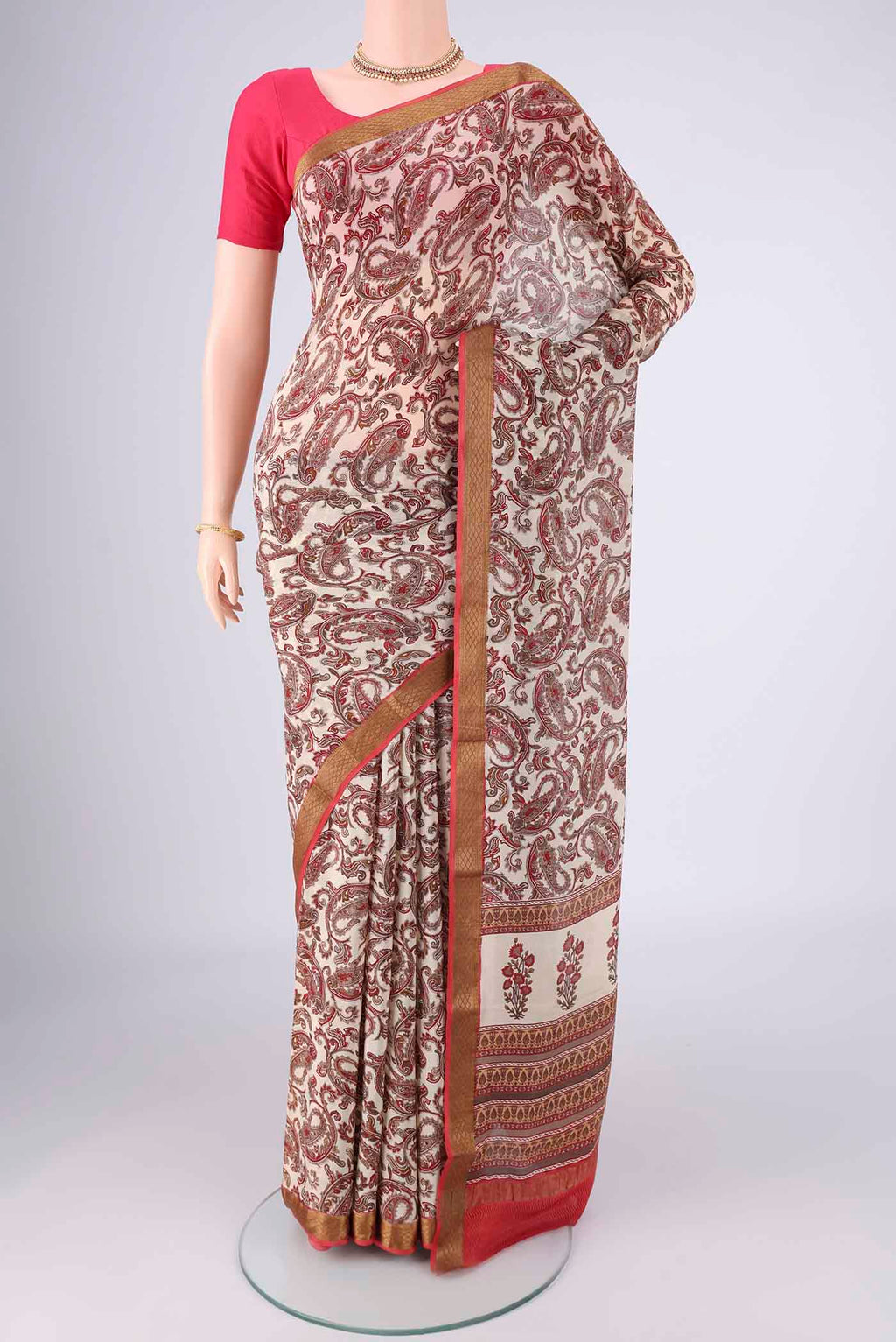 Off White Mysore Crepe Saree with Printed design on the body and Zari Border.  displayed on a mannequin
