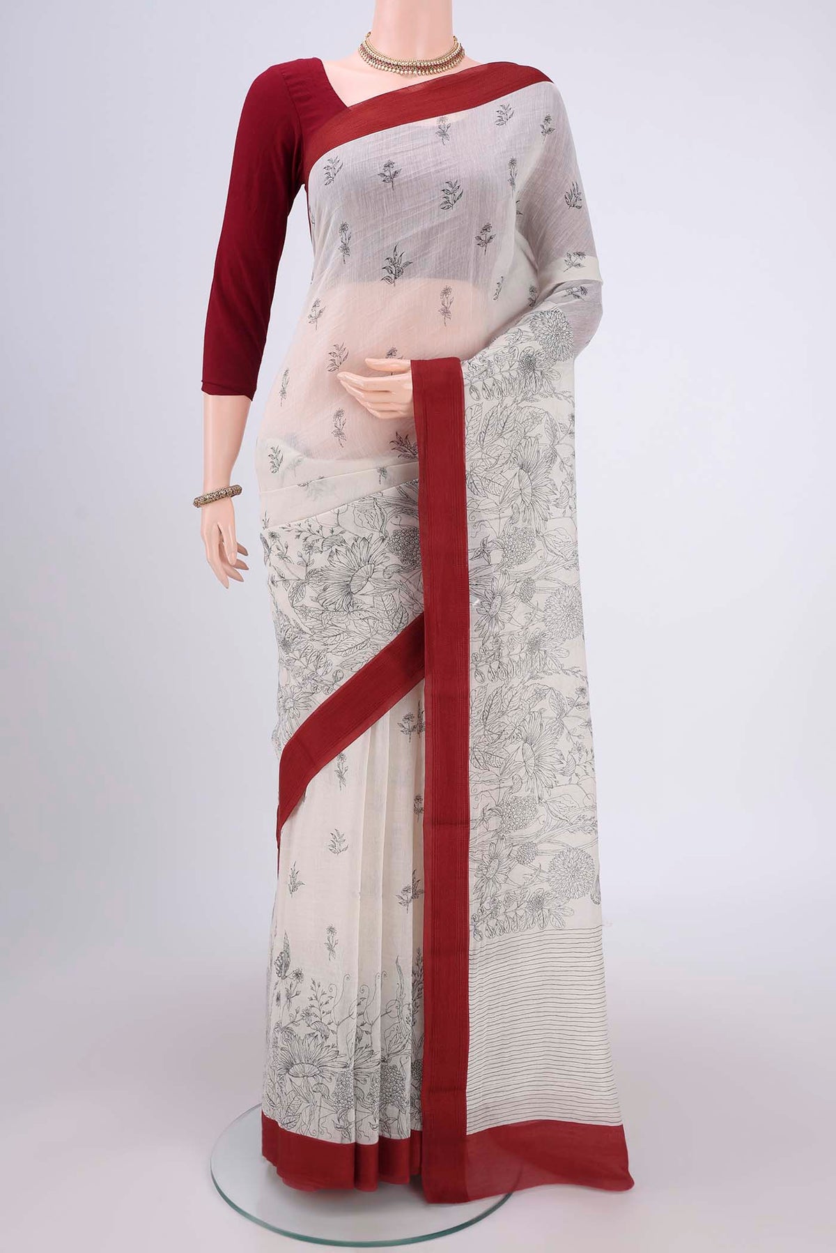 White Silk Cotton Saree with Printed design on the body and Plain Border.  displayed on a mannequin