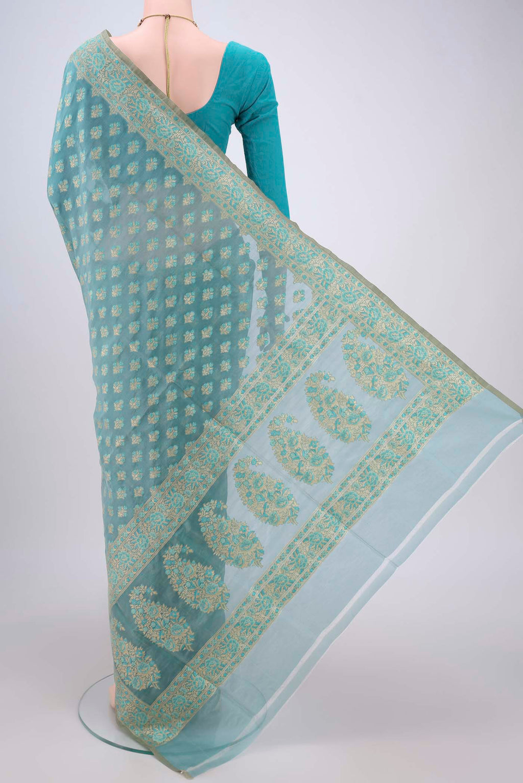 Flat view of Sky Blue Banarasi Silk Saree with Zari And Thread Butta on the body and Zari Border. 