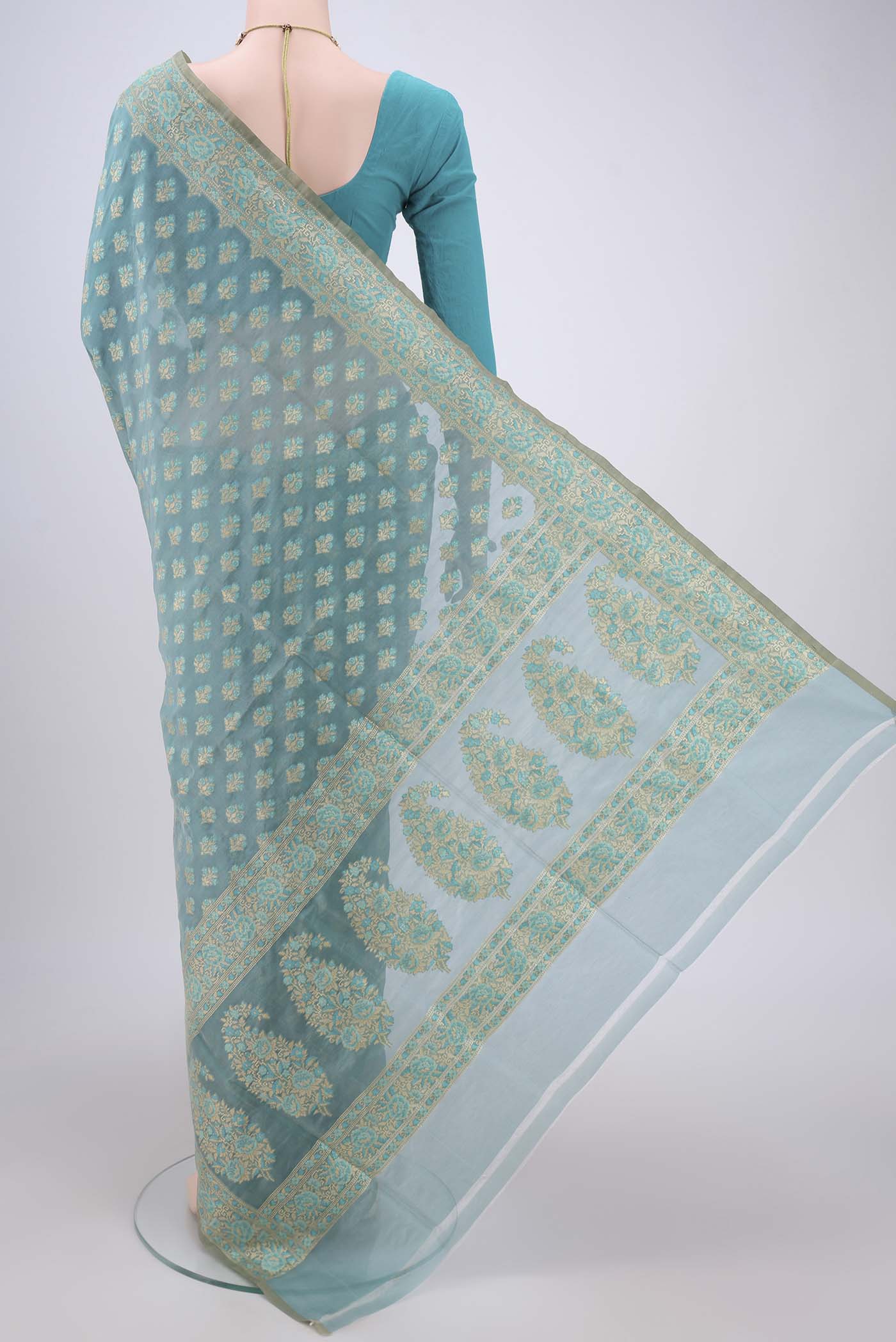 Flat view of Sky Blue Banarasi Silk Saree with Zari And Thread Butta on the body and Zari Border. 