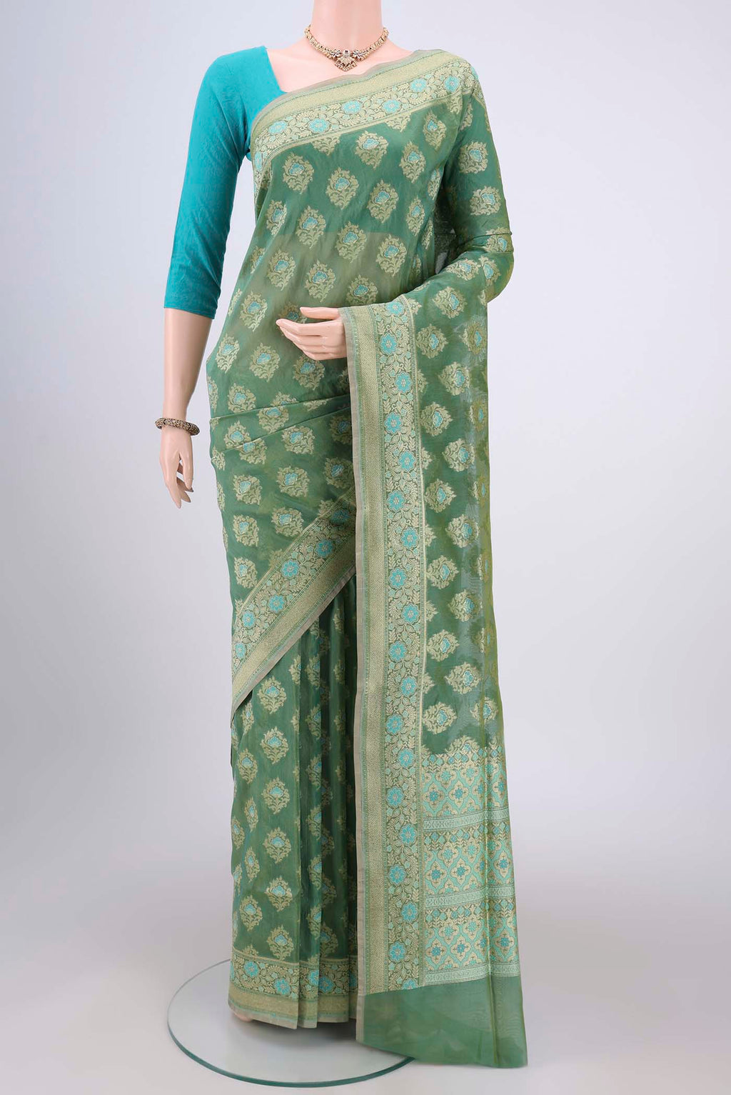 Mint Green Banarasi Silk Saree with Zari And Thread Butta on the body and Zari Border.  displayed on a mannequin