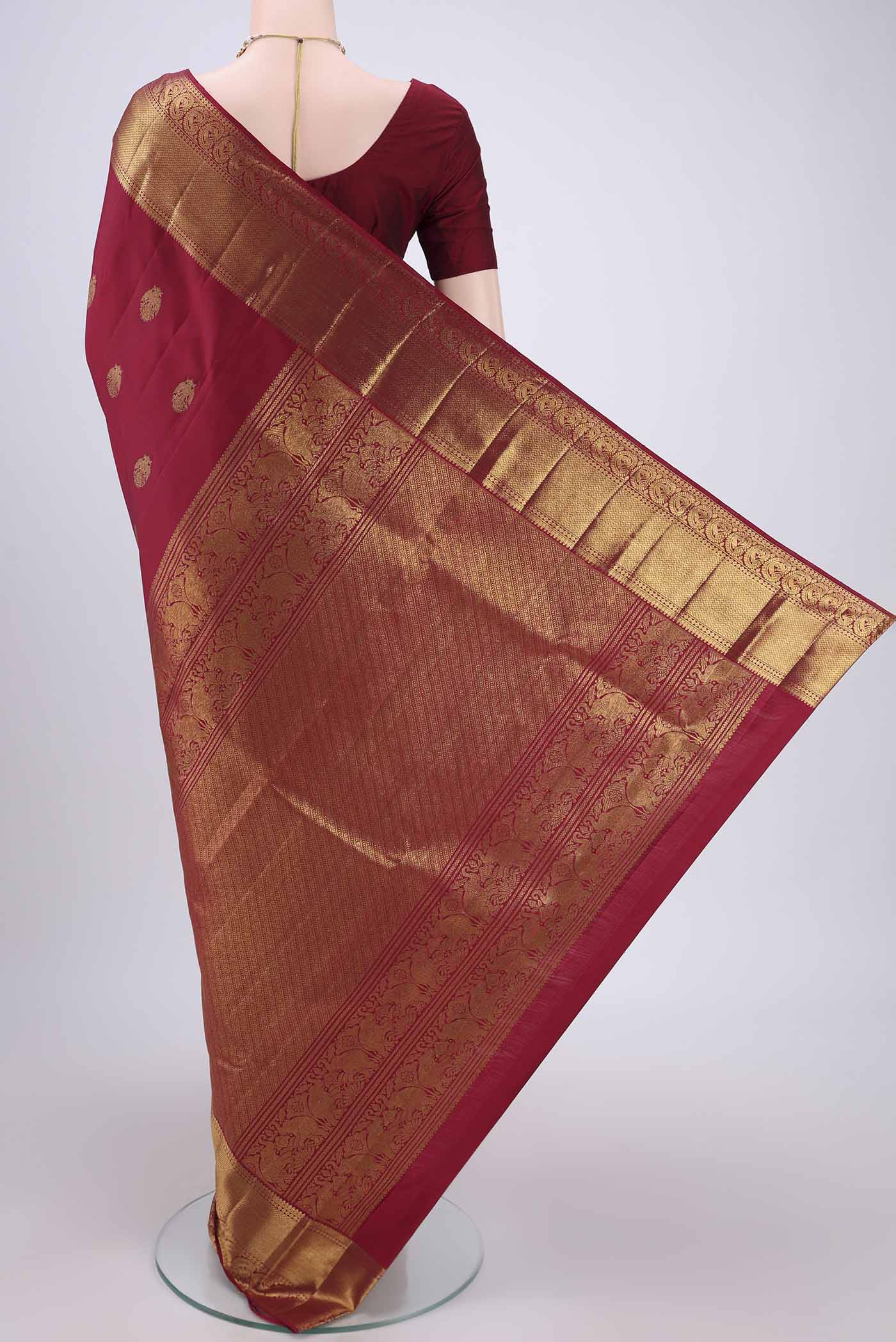 Flat view of Maroon Kanjivaram Silk Saree with Zari Butta on the body and Zari Border. 