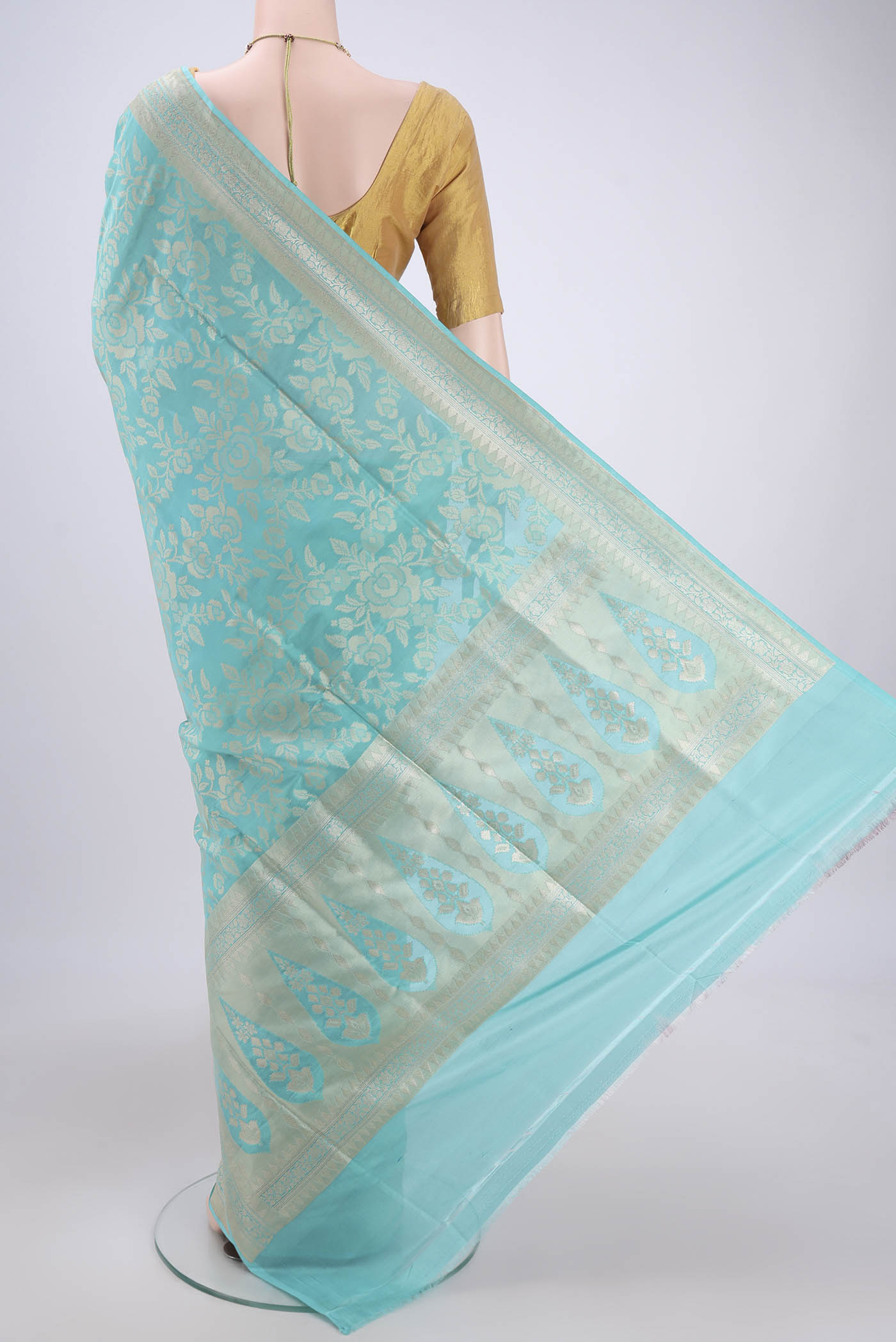 Flat view of Sky Blue Banarasi Silk Saree with Zari And Thread Butta on the body and Zari Border. 