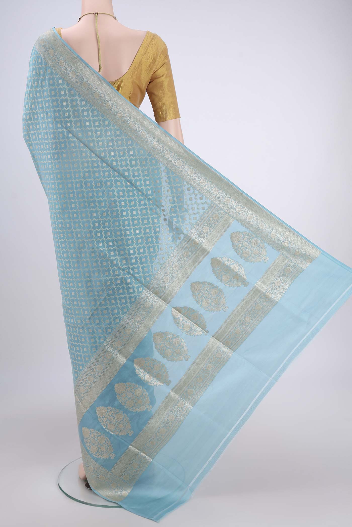 Flat view of Sky Blue Banarasi Silk Saree with Zari And Thread Butta on the body and Zari Border. 
