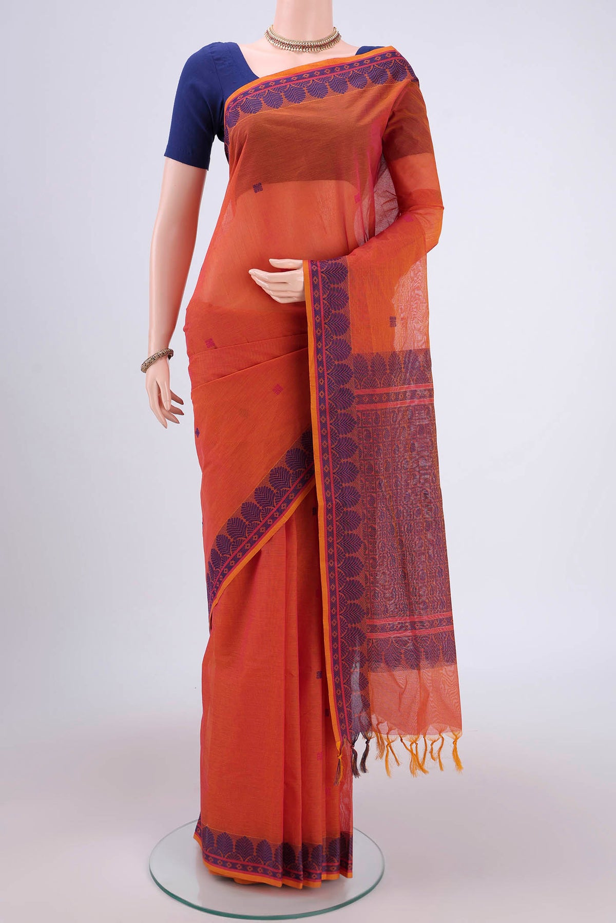 Orange Coimbatore Cotton Saree with Thread Butta on the body and Thread Border.  displayed on a mannequin