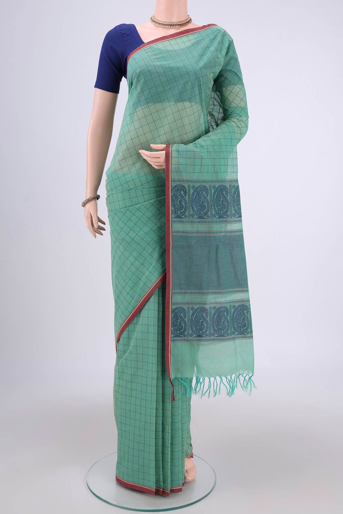 Mint Green Coimbatore Cotton Saree with Thread Butta on the body and Thread Border.  displayed on a mannequin