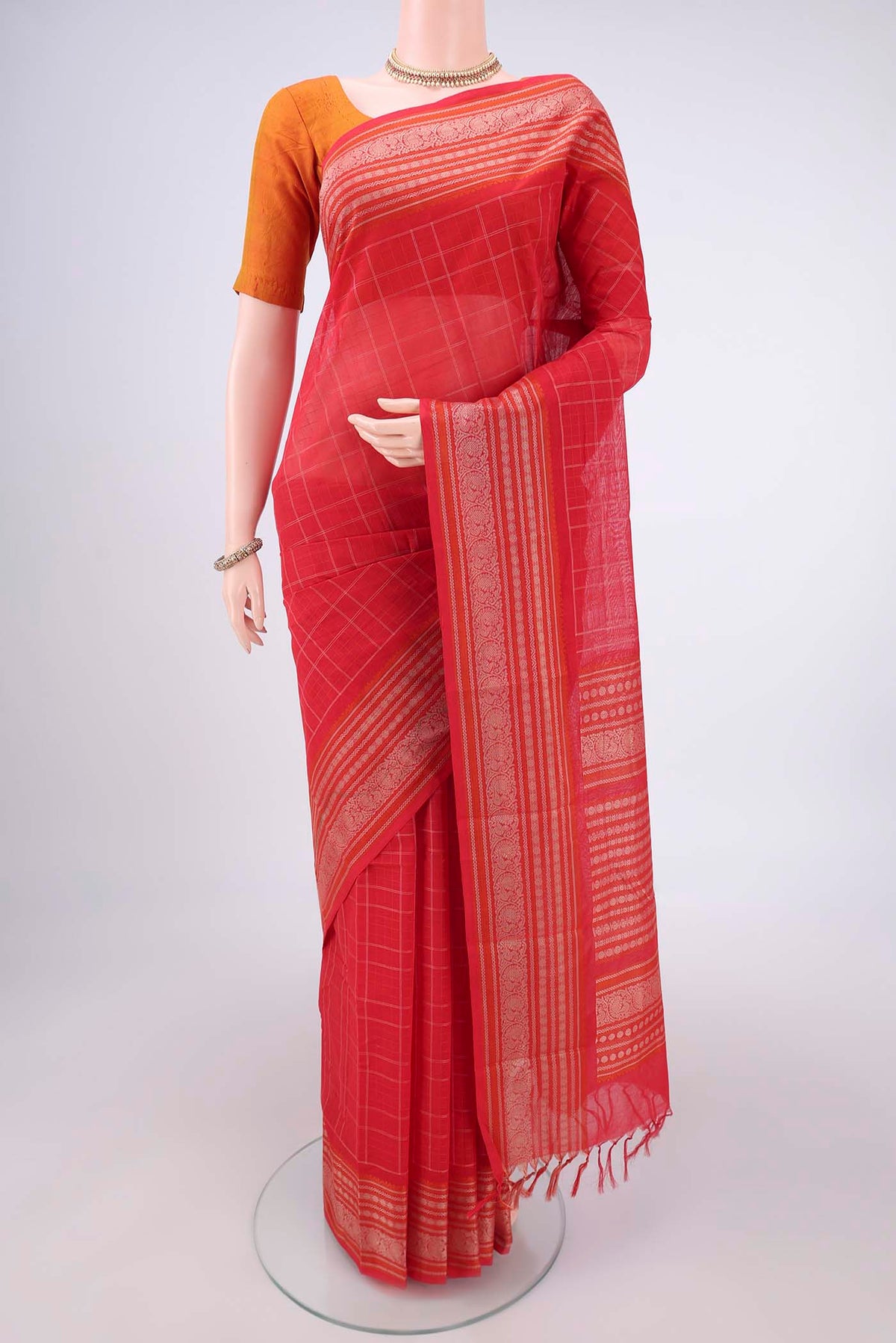 Red Kanchi Cotton Saree with Checked design on the body and Thread Border.  displayed on a mannequin
