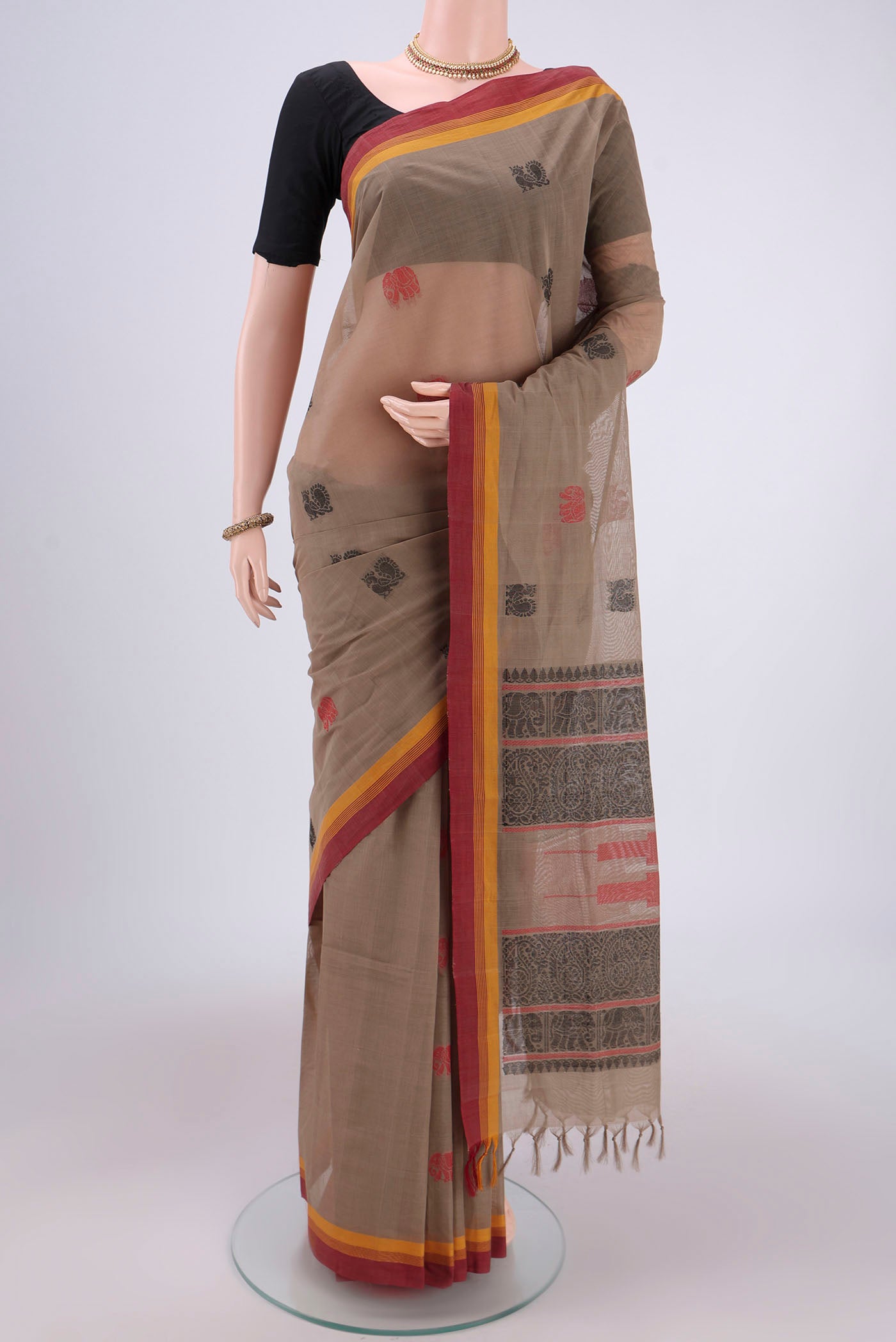 Brown Coimbatore Cotton Saree with Thread Butta on the body and Thread Border.  displayed on a mannequin