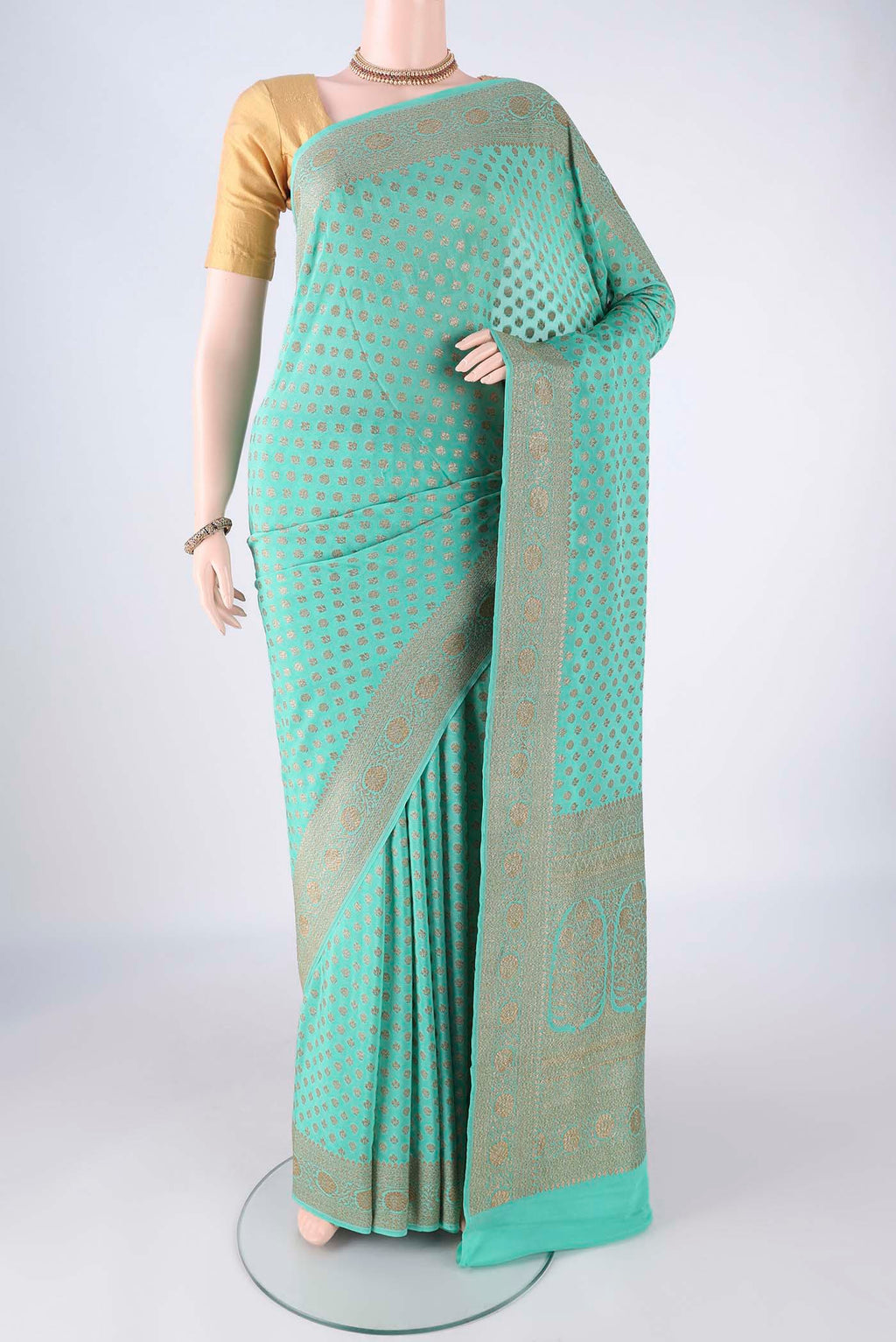 Turquoise Banarasi Georgette Saree with Zari Butta on the body and Zari Border.  displayed on a mannequin