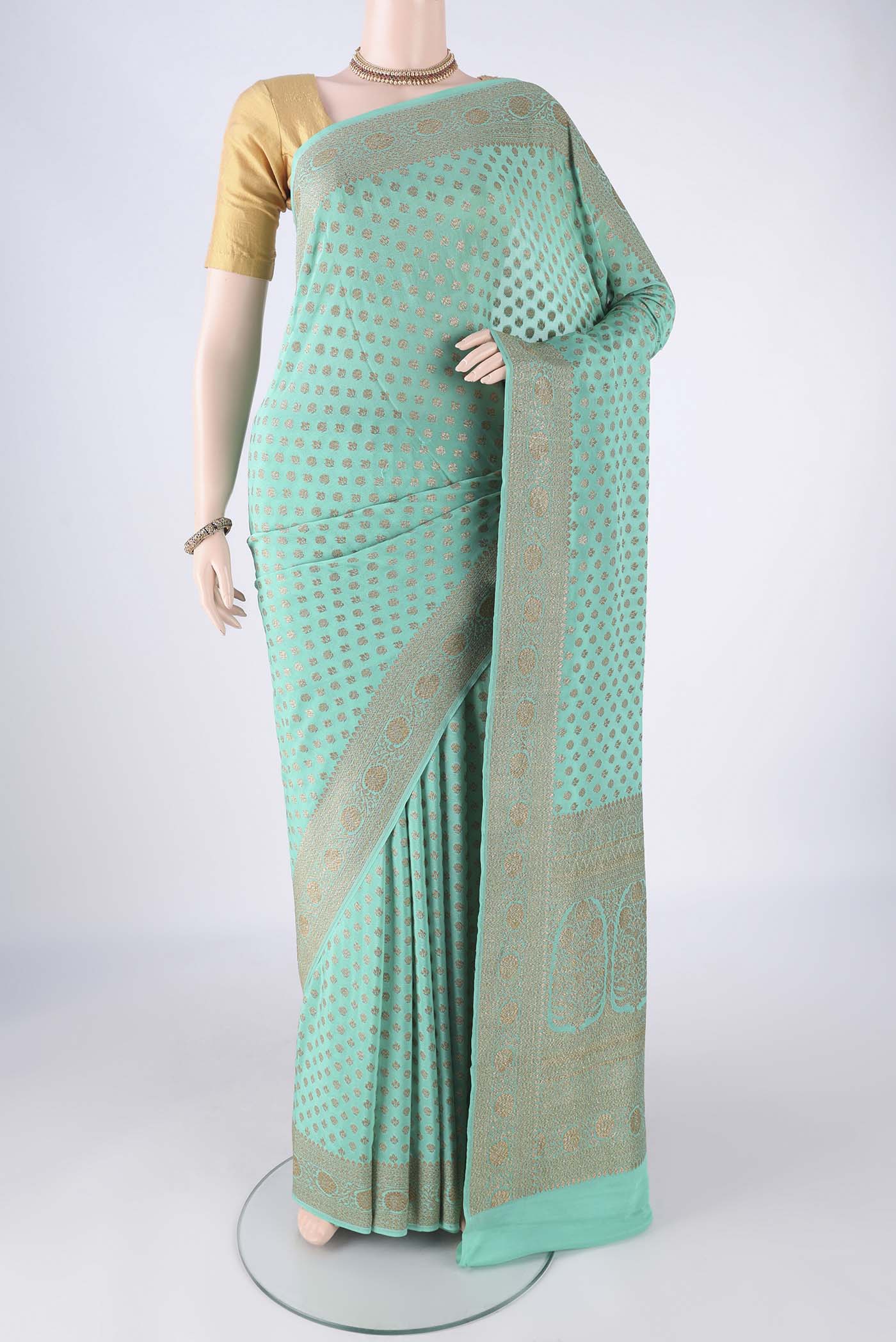 Turquoise Banarasi Georgette Saree with Zari Butta on the body and Zari Border.  displayed on a mannequin