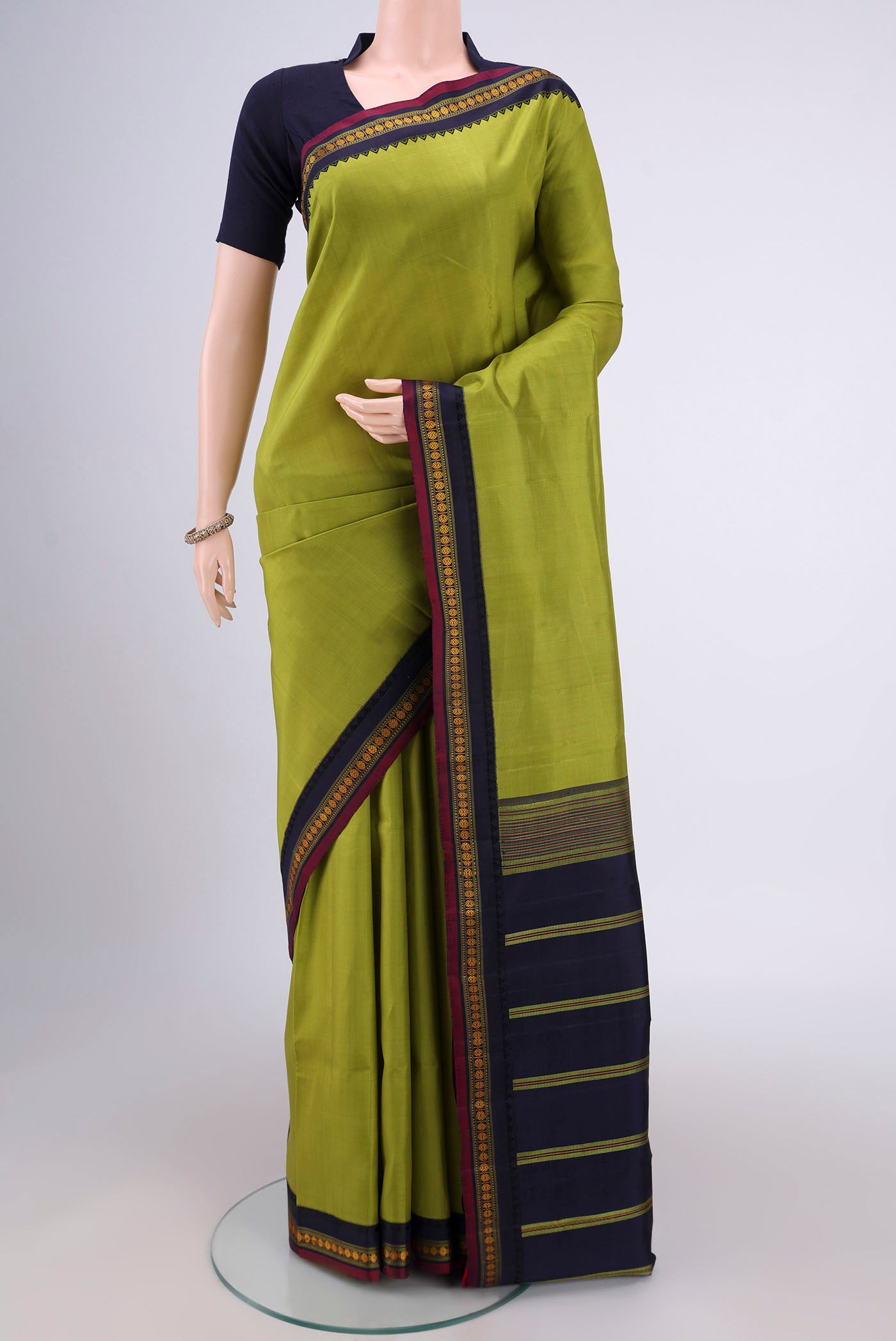 Light Green Dual Tone Kanjivaram Silk Saree with Plain Body and Thread Border.  displayed on a mannequin