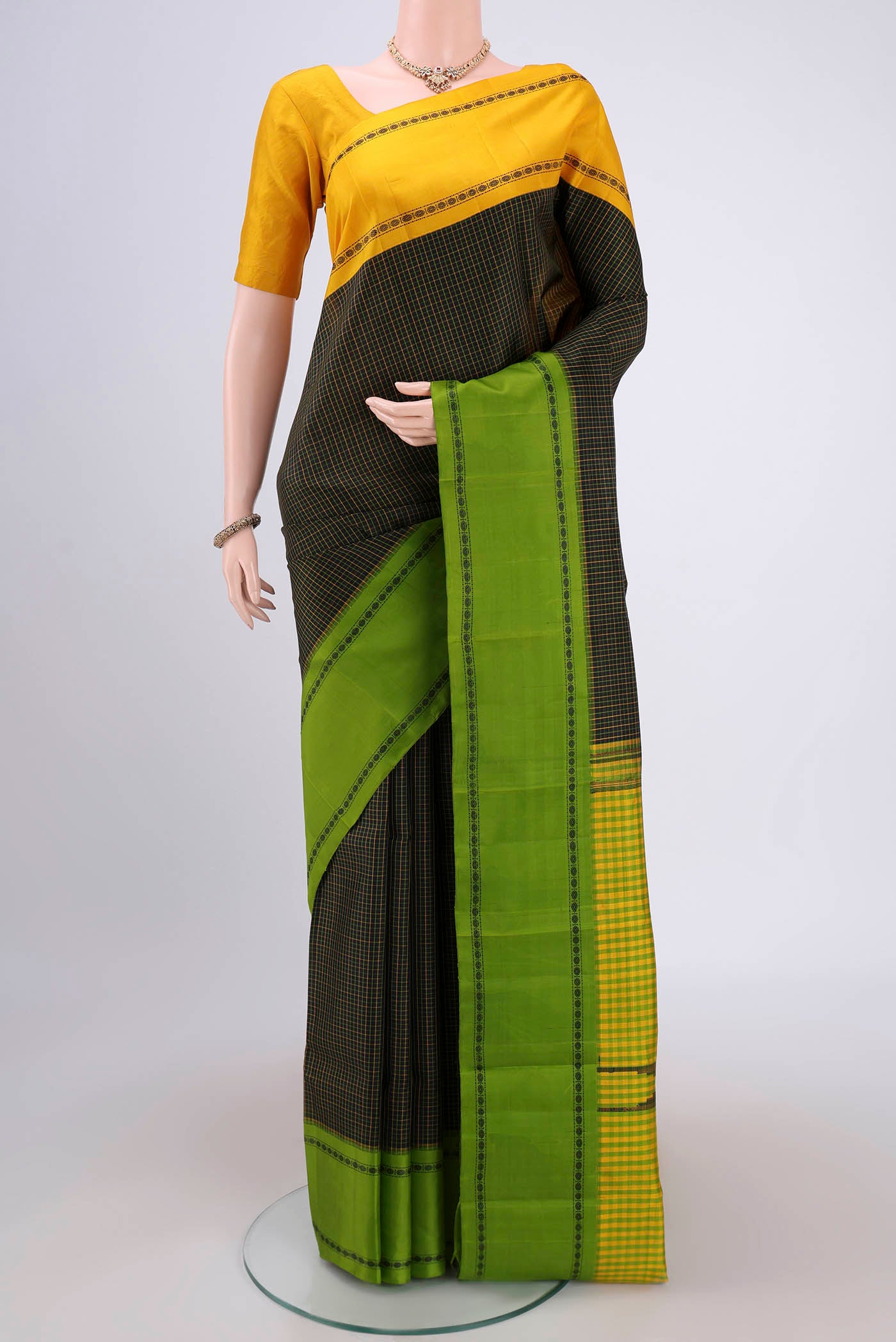 Black Dual Tone Kanchipuram Silk Saree with Checked design on the body and Ganga Jamuna Border.  displayed on a mannequin