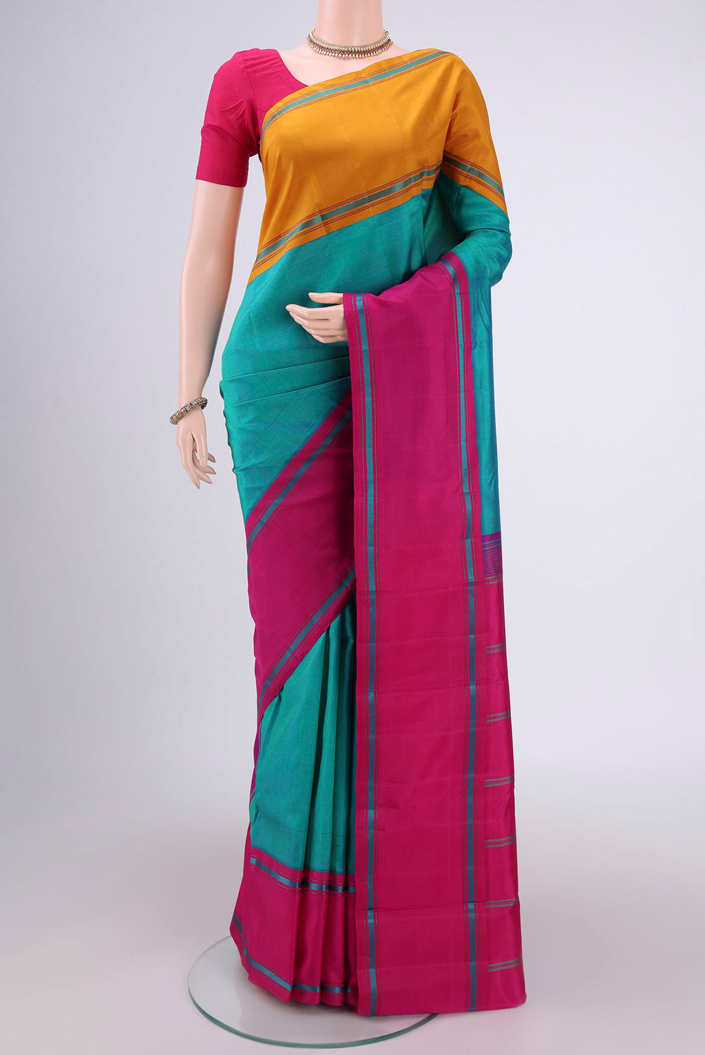 Sea Green Kanjivaram Silk Saree with Plain Body and Ganga Jamuna Border.  displayed on a mannequin
