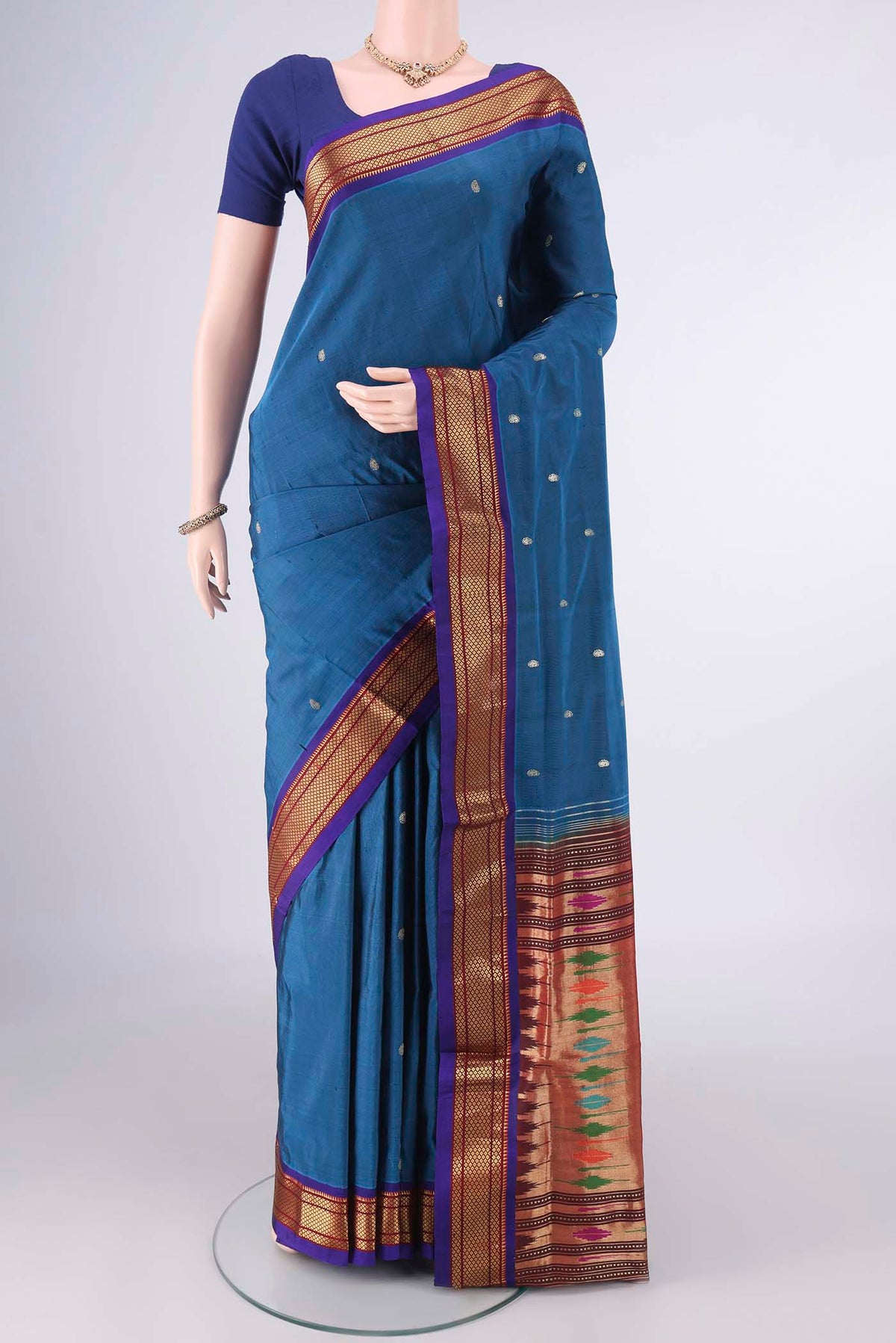 Pure Silk Peacock Blue Paithani Saree with Zari Butta on the body and Zari Border.  displayed on a mannequin