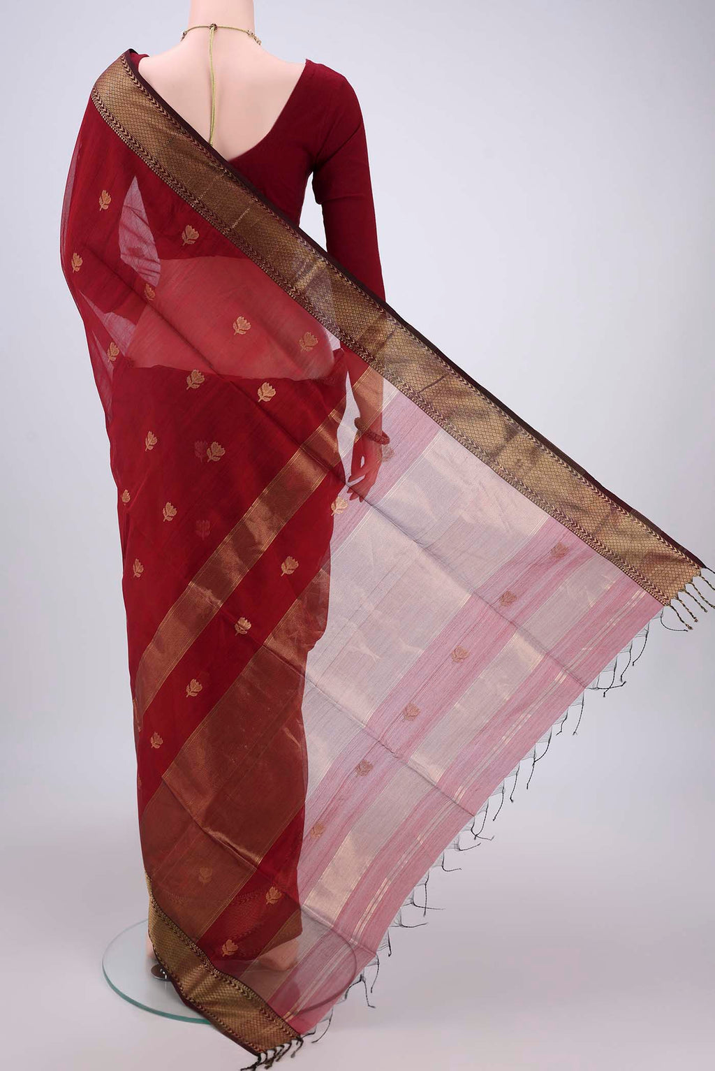 Flat view of Maroon Maheshwari Silk Cotton Saree with Zari Butta on the body and Zari Border. 