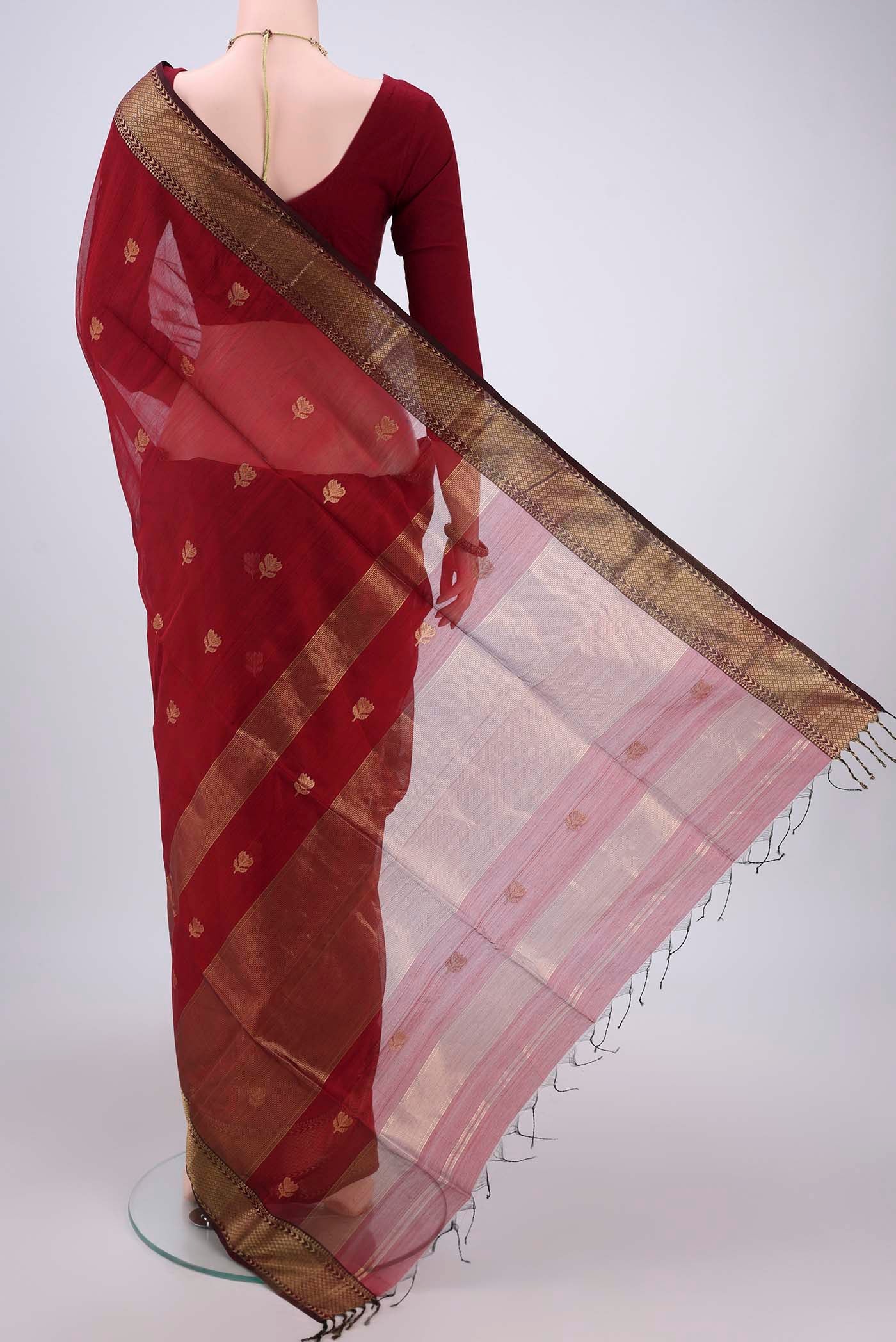 Flat view of Maroon Maheshwari Silk Cotton Saree with Zari Butta on the body and Zari Border. 