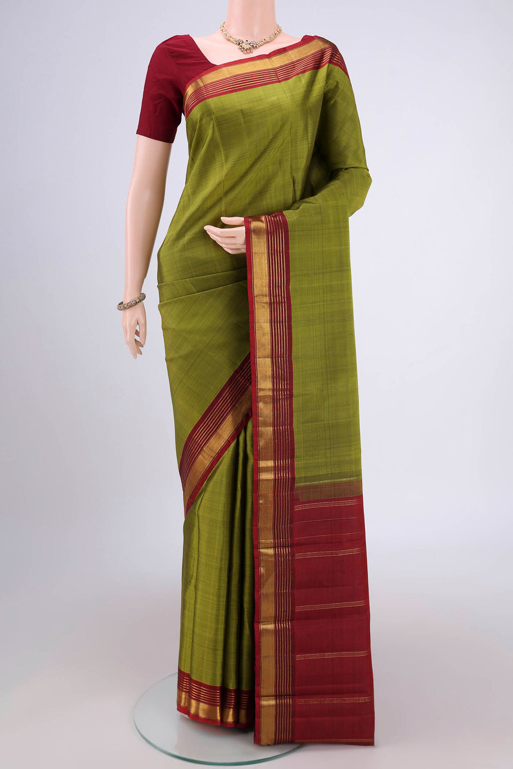 Mehandi Green Kanjivaram Silk Saree with Plain Body and Zari Border.  displayed on a mannequin