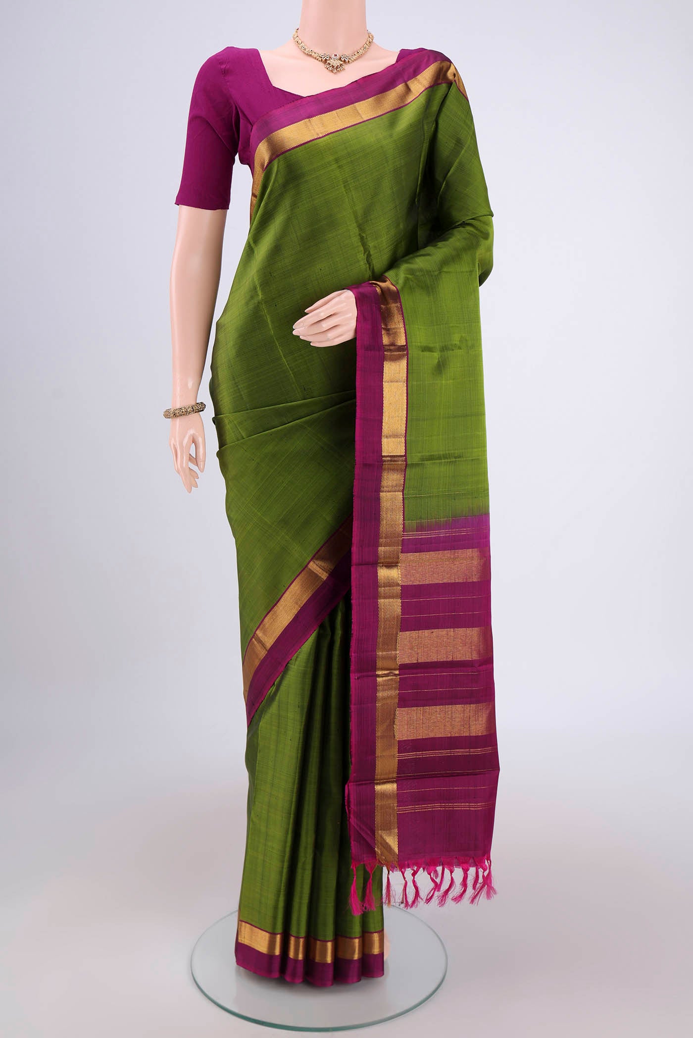 Mehandi Green Dual Tone Kanjivaram Silk Saree with Plain Body and Zari Border.  displayed on a mannequin