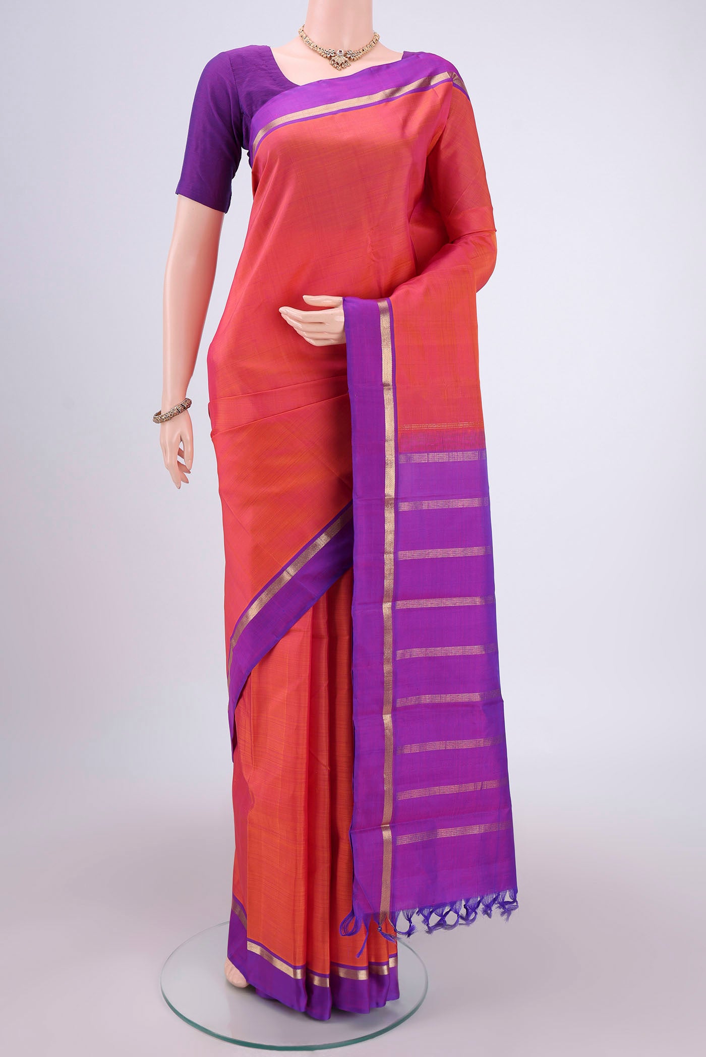 Orange Kanjivaram Silk Saree with Plain Body and Zari Border.  displayed on a mannequin