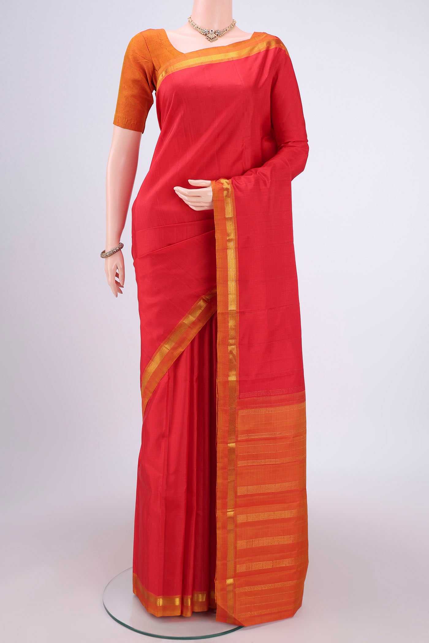 Red Kanjivaram Silk Saree with Plain Body and Zari Border.  displayed on a mannequin