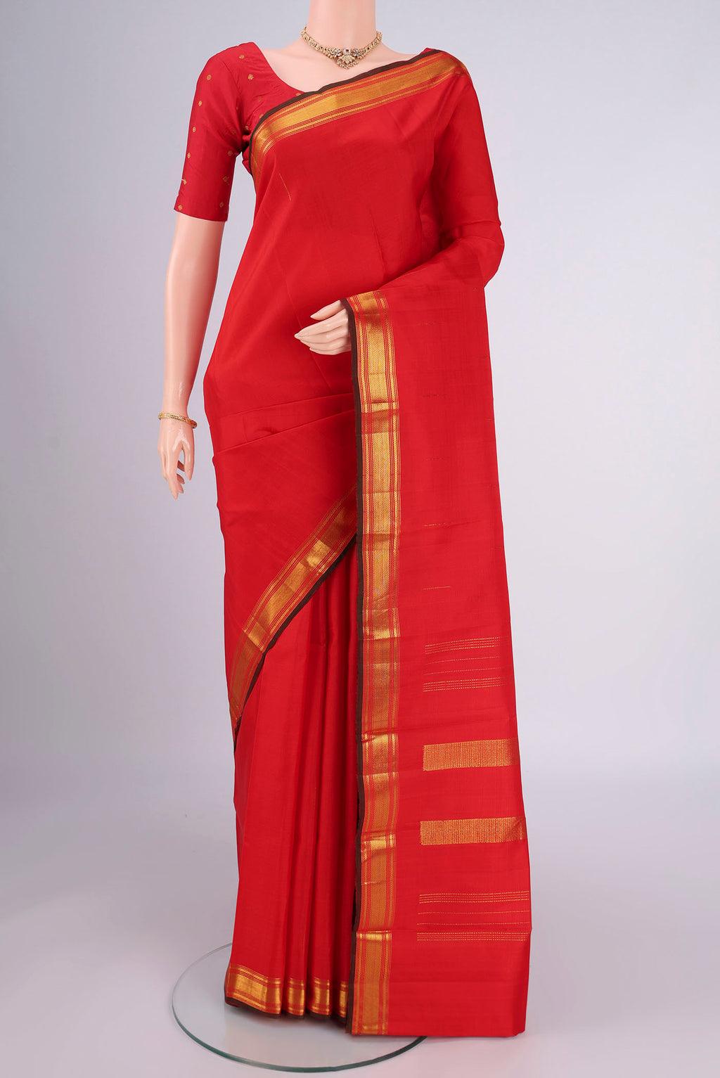 Red Kanchipuram Silk Saree with Zari Butta on the body and Zari Border.  displayed on a mannequin