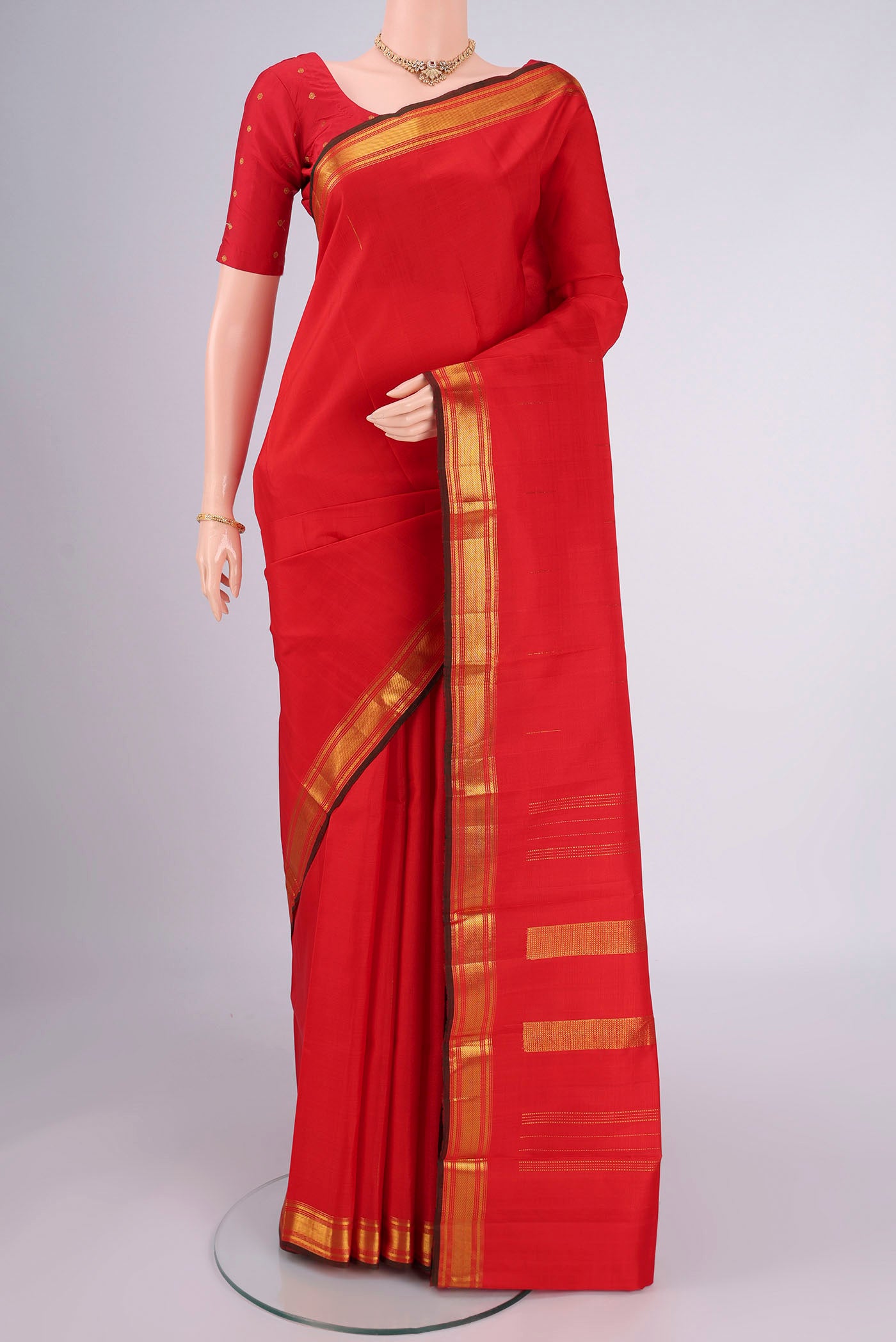 Red Kanchipuram Silk Saree with Zari Butta on the body and Zari Border.  displayed on a mannequin