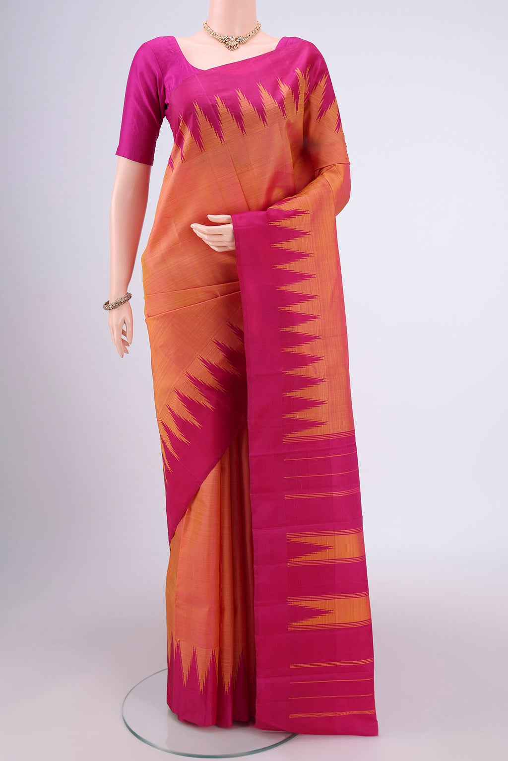 Peach Kanchipuram Silk Saree with Plain Body and Temple Border.  displayed on a mannequin
