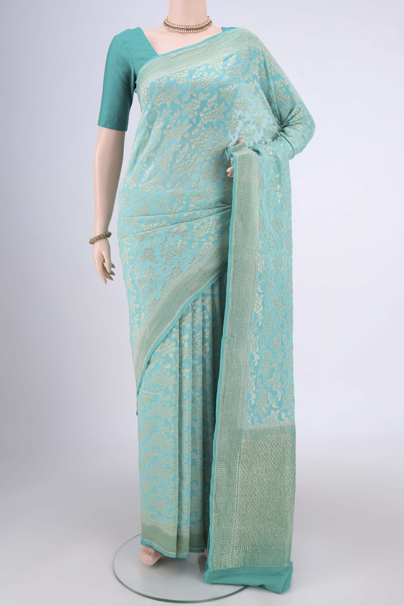 Turquoise Banarasi Georgette Saree with Zari Brocade on the body and Zari Border.  displayed on a mannequin