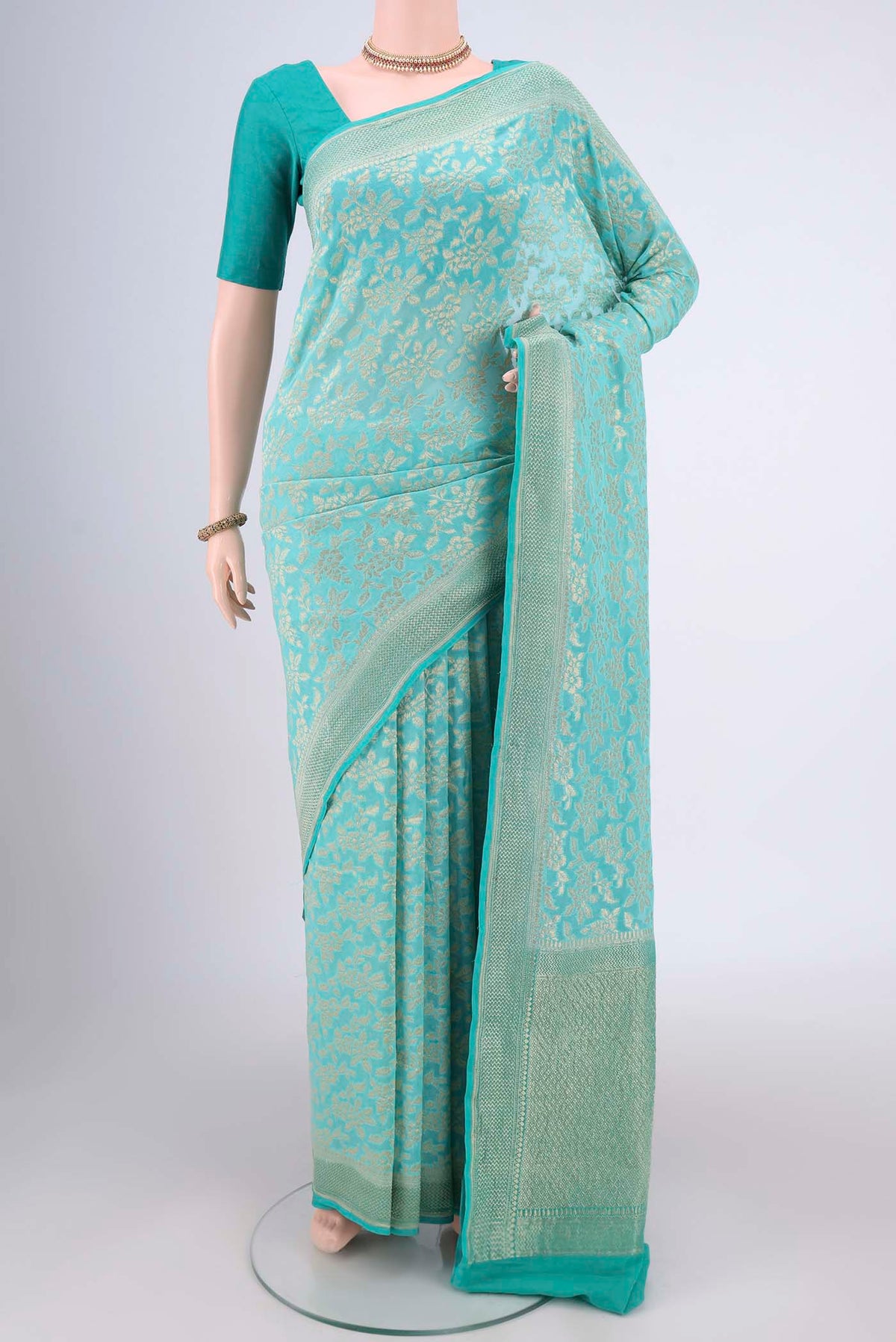 Turquoise Banarasi Georgette Saree with Zari Brocade on the body and Zari Border.  displayed on a mannequin
