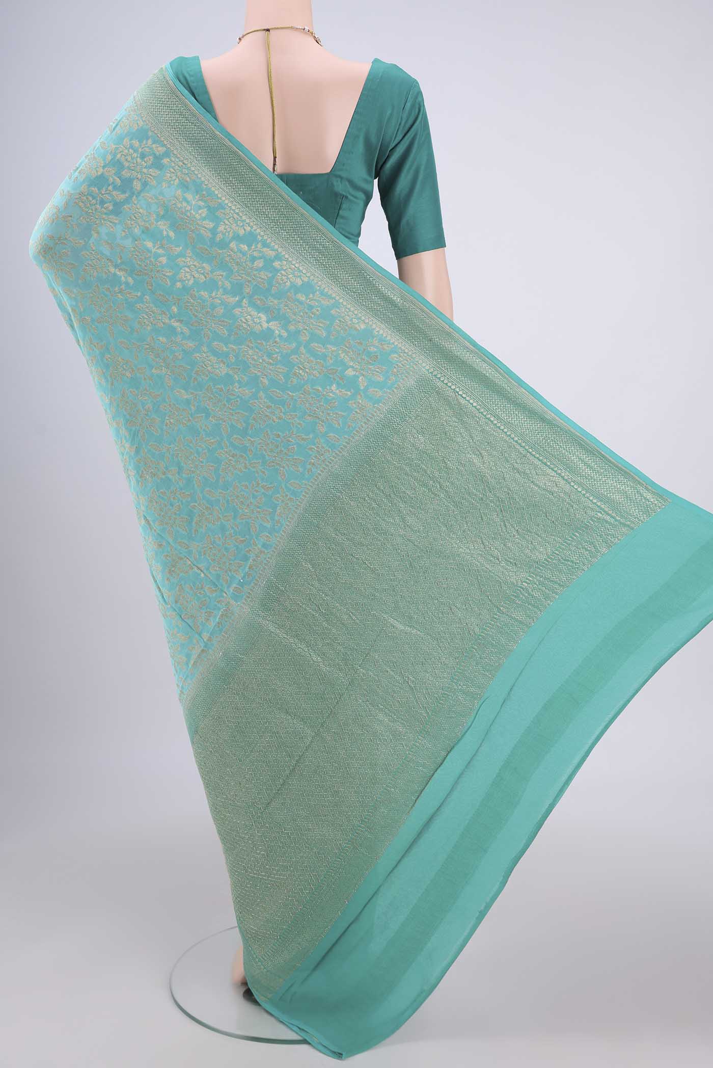 Flat view of Turquoise Banarasi Georgette Saree with Zari Brocade on the body and Zari Border. 