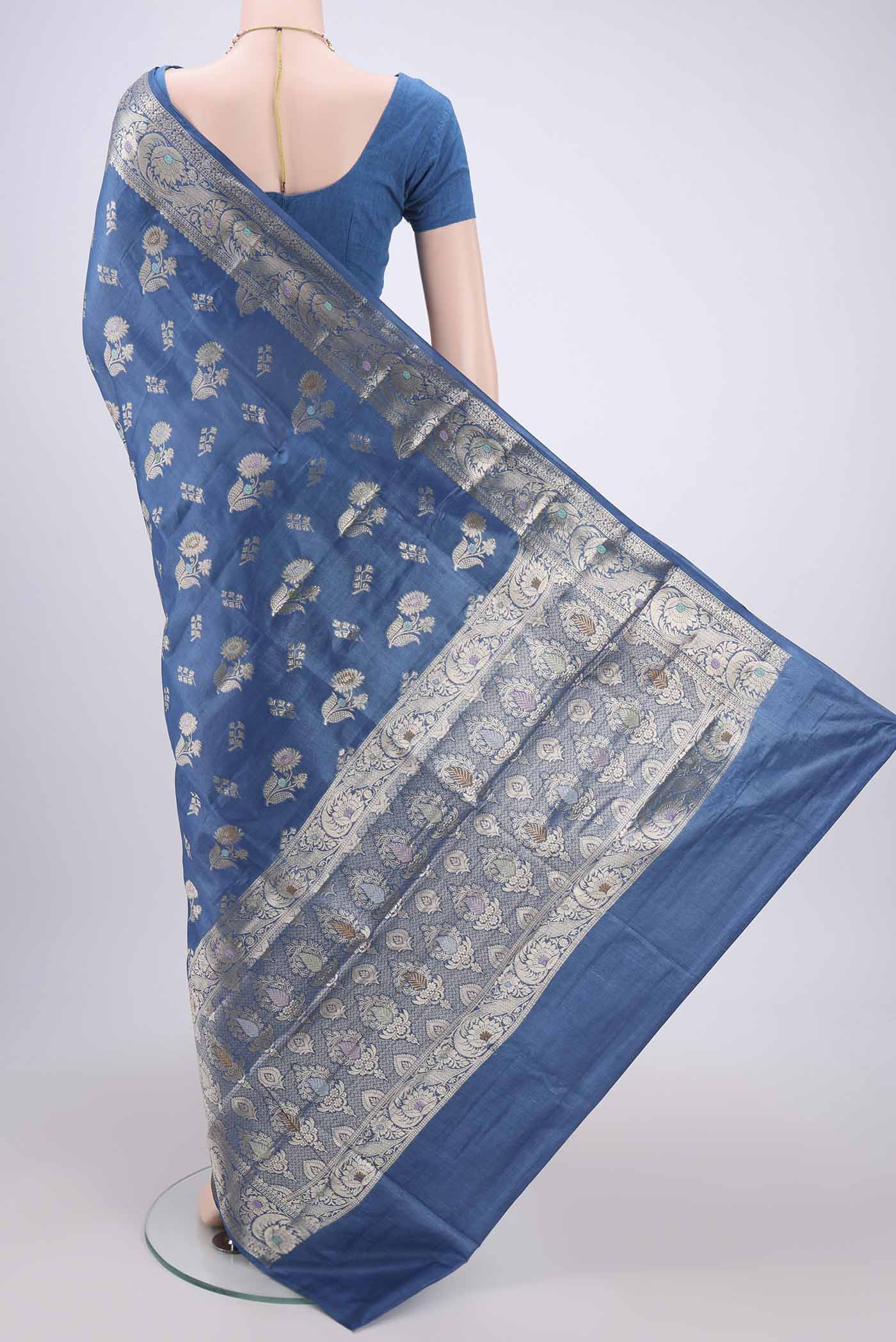 Flat view of Blue Banarasi Tussar Silk Saree with Zari And Thread Butta on the body and Zari And Thread Border. 
