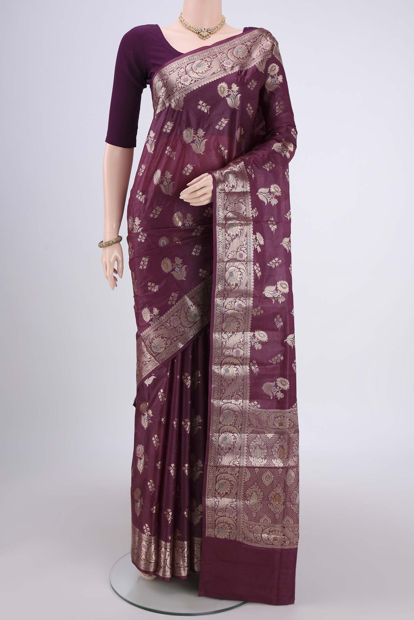 Burgundy Banarasi Tussar Silk Saree with Zari And Thread Butta on the body and Zari And Thread Border.  displayed on a mannequin