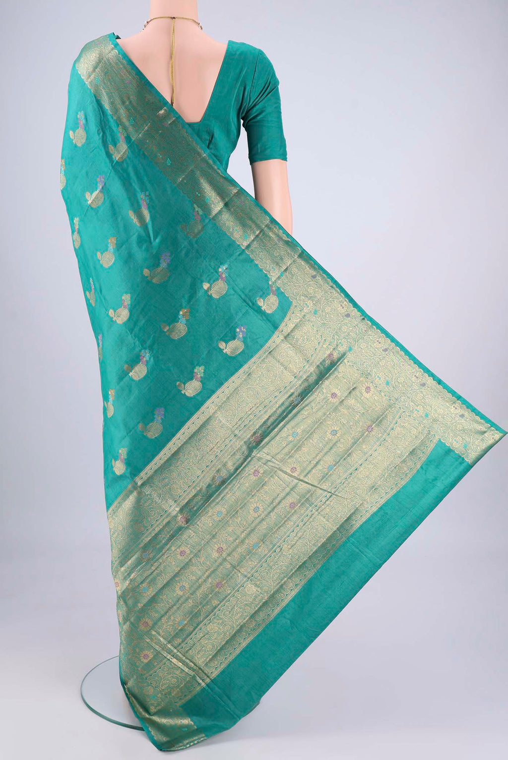 Flat view of Turquoise Banarasi Tussar Silk Saree with Zari And Thread Butta on the body and Zari And Thread Border. 