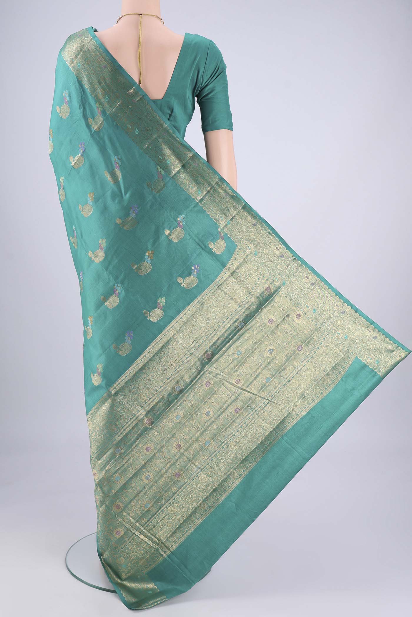 Flat view of Turquoise Banarasi Tussar Silk Saree with Zari And Thread Butta on the body and Zari And Thread Border. 