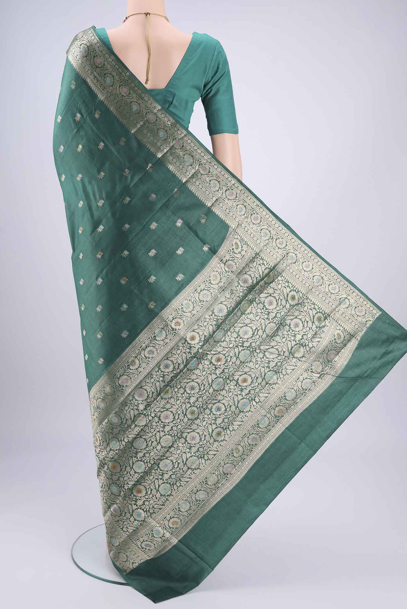 Flat view of Green Banarasi Tussar Silk Saree with Zari Butta on the body and Zari And Thread Border. 