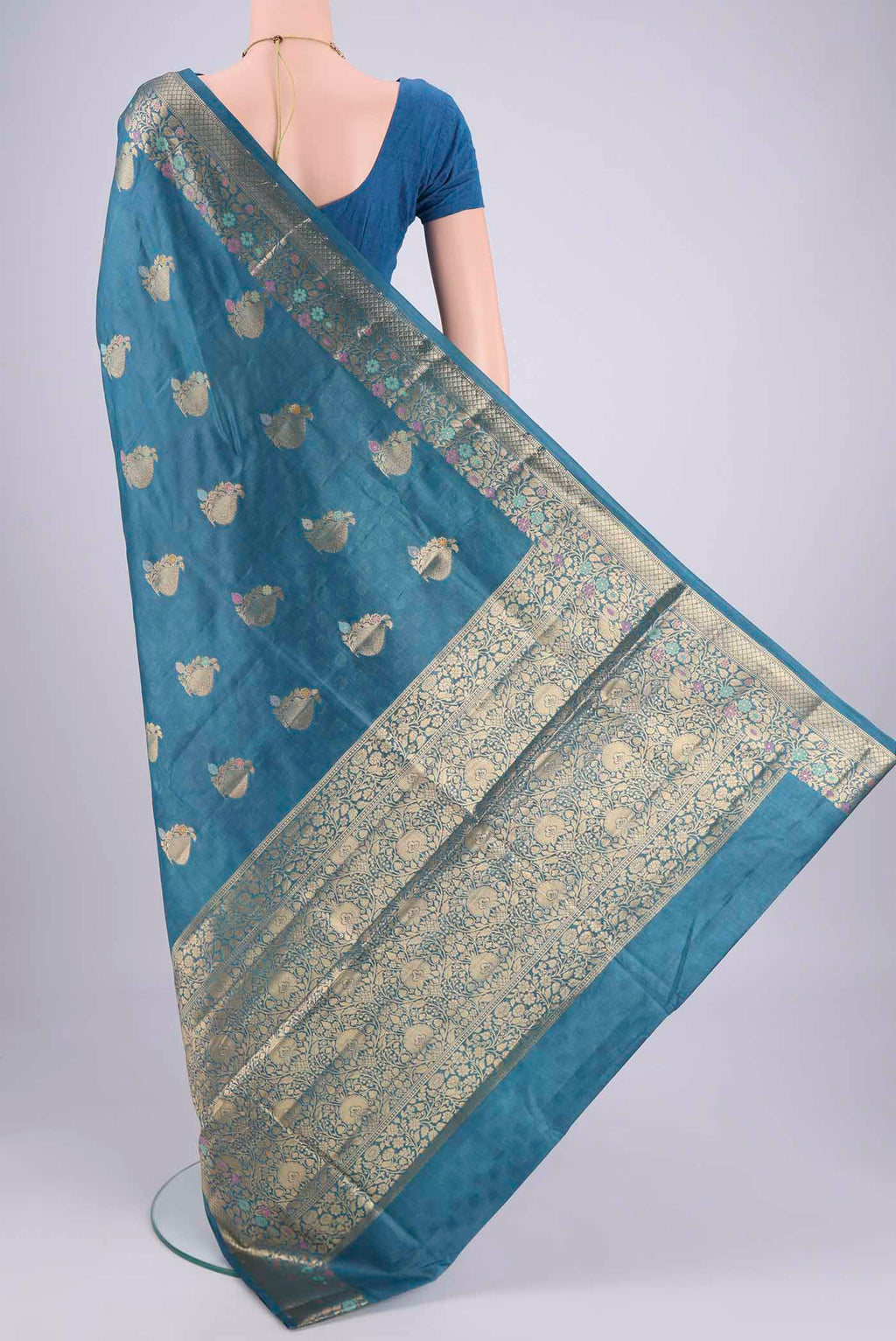 Flat view of Blue Banarasi Tussar Silk Saree with Zari And Thread Butta on the body and Zari And Thread Border. 