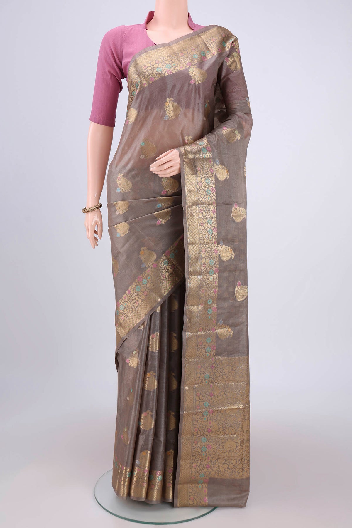 Beige Banarasi Tussar Silk Saree with Zari And Thread Butta on the body and Zari And Thread Border.  displayed on a mannequin