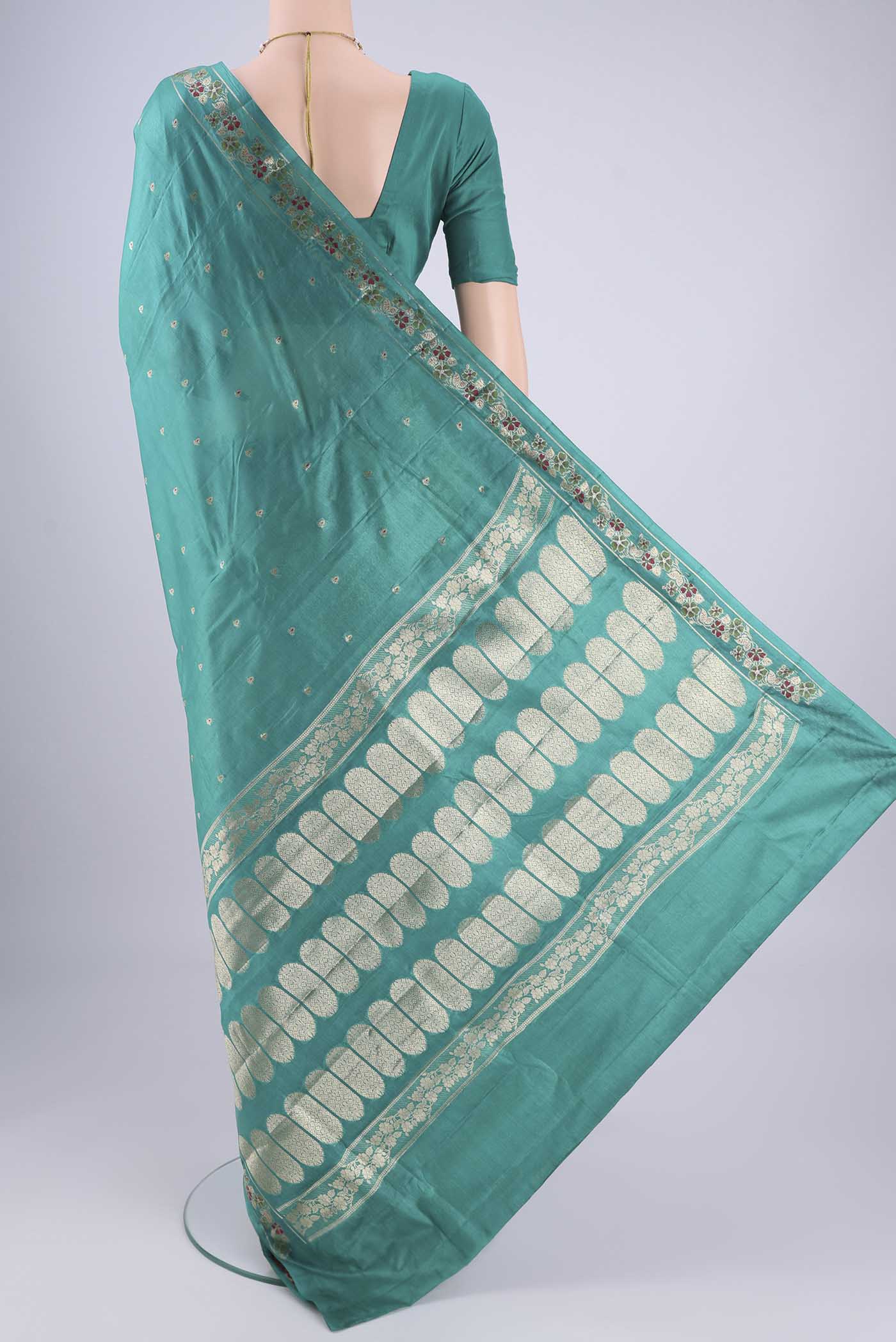 Flat view of Turquoise Banarasi Tussar Silk Saree with Zari And Thread Butta on the body and Zari And Thread Border. 
