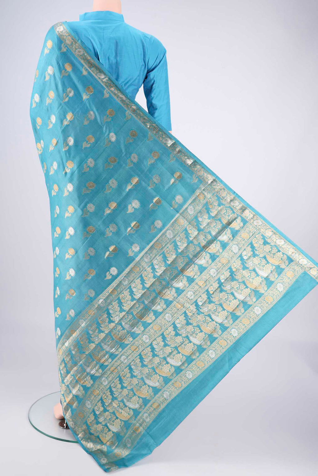 Flat view of Blue Banarasi Tussar Silk Saree with Zari Butta on the body and Zari Border. 