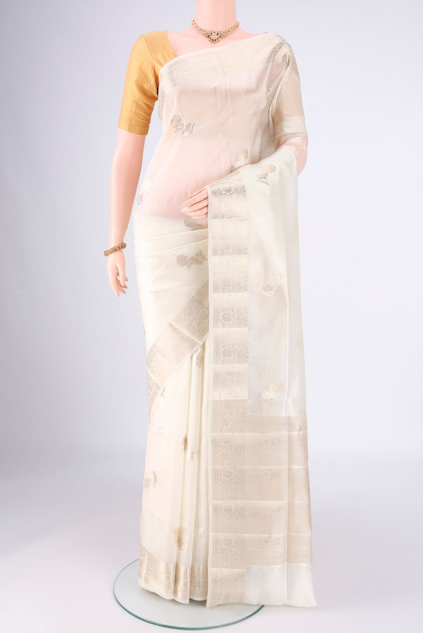 Off White Banarasi Raw Silk Saree with Zari Butta on the body and Zari Border.  displayed on a mannequin