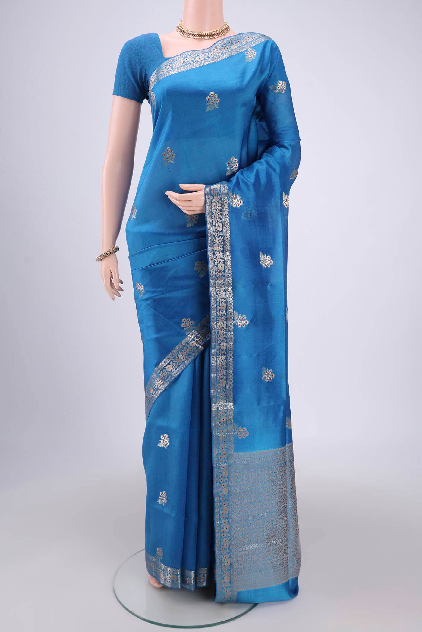 Electric Blue Banarasi Raw Silk Saree with Zari And Thread Butta on the body and Zari And Thread Border.  displayed on a mannequin