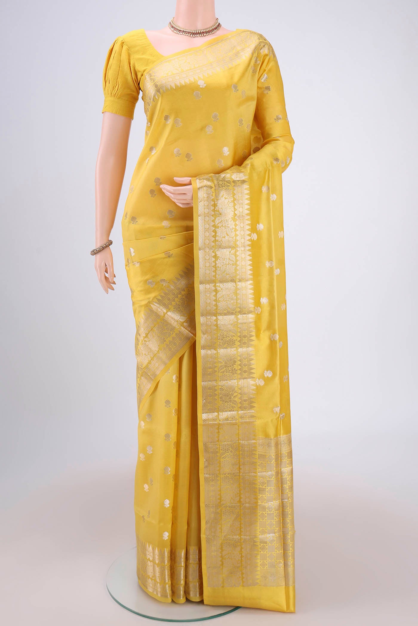 Lemon Yellow Banarasi Raw Silk Saree with Zari Butta on the body and Zari Border.  displayed on a mannequin